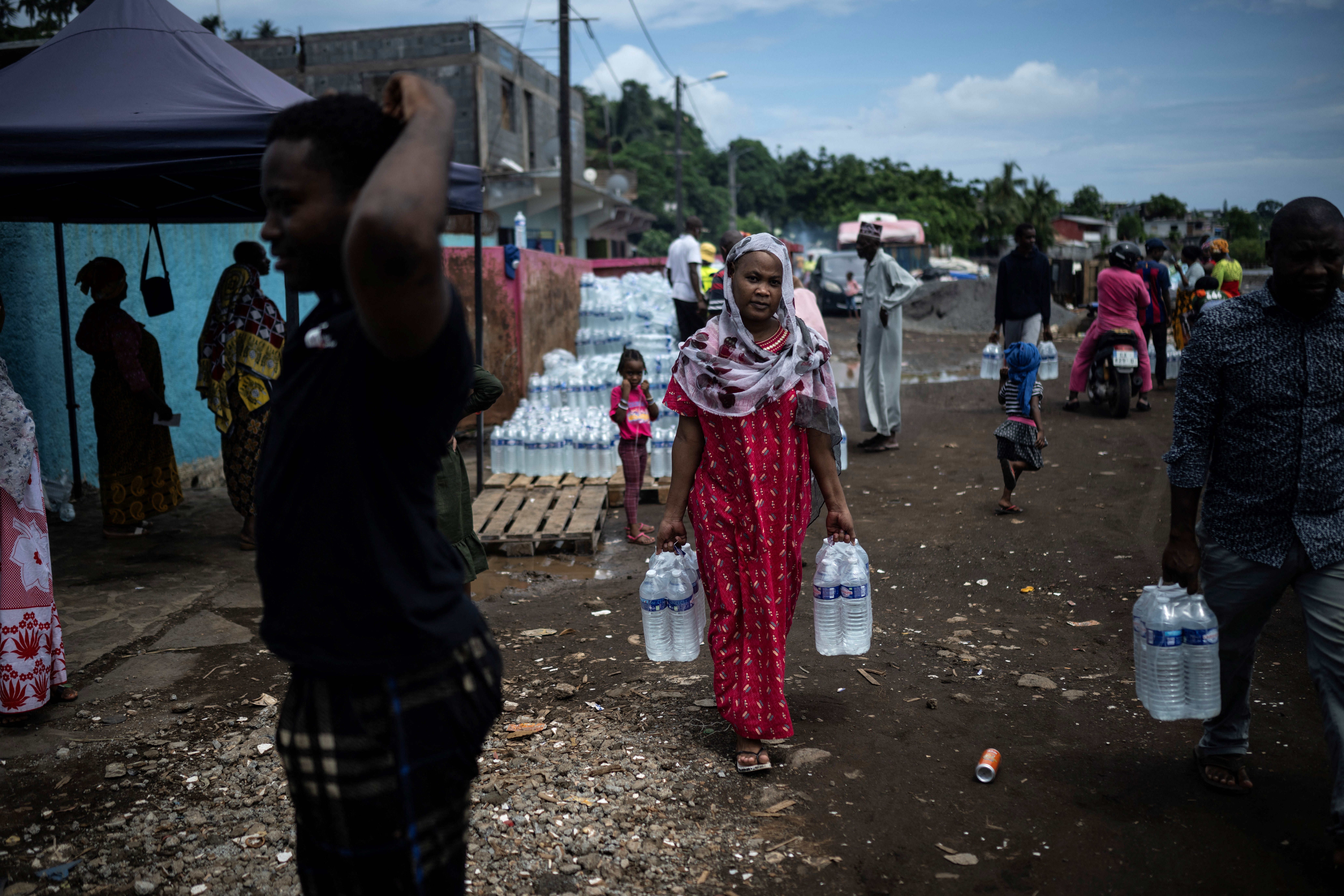 File image: People collect bottled drinking water from a distribution point in the Majicavo district in Mamoudzou on the French Indian Ocean island of Mayotte