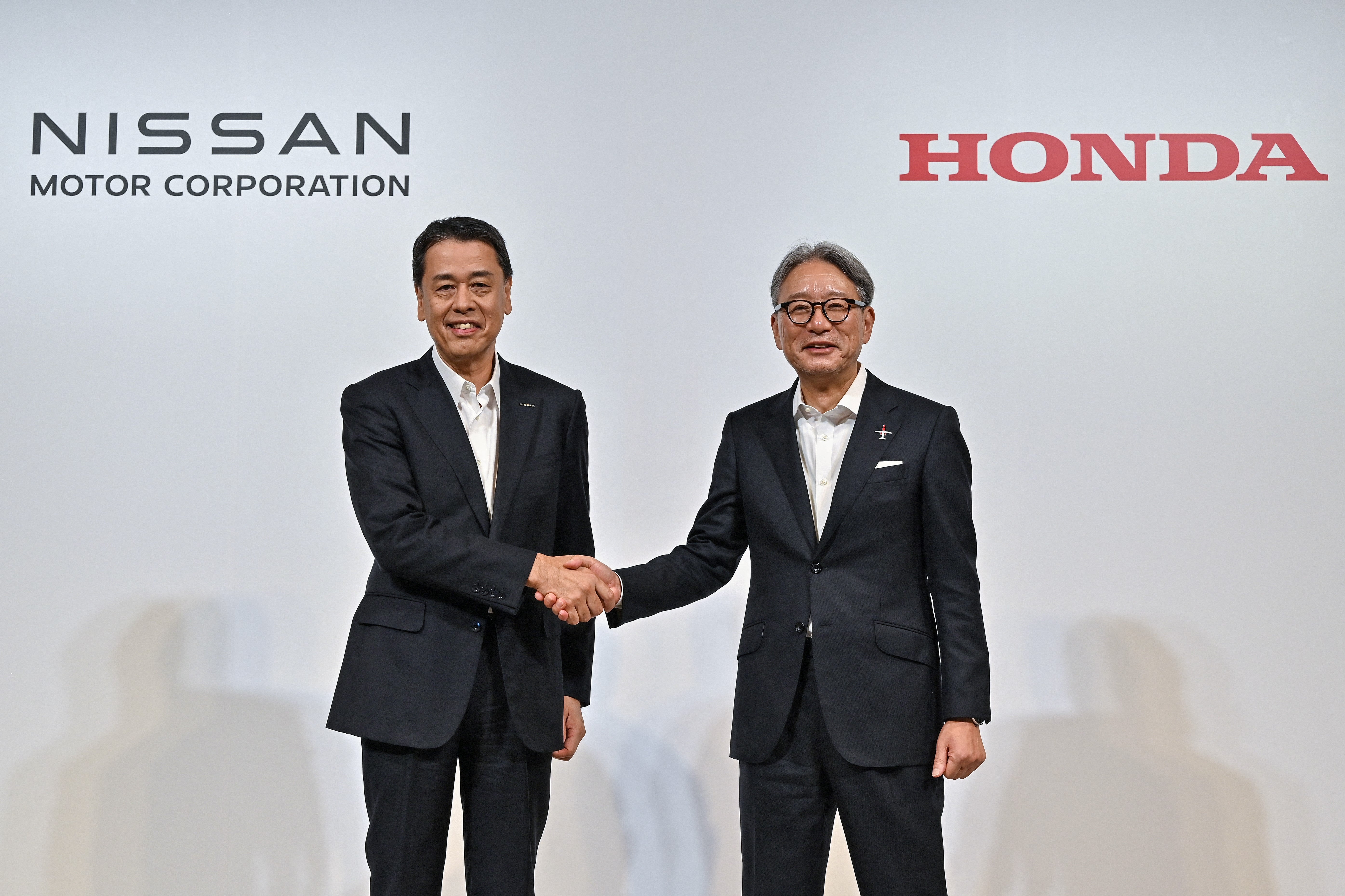 File. Nissan CEO Makoto Uchid, left, shakes hands with Honda president Toshihiro Mibe in Tokyo, Japan, on 11 August 2024