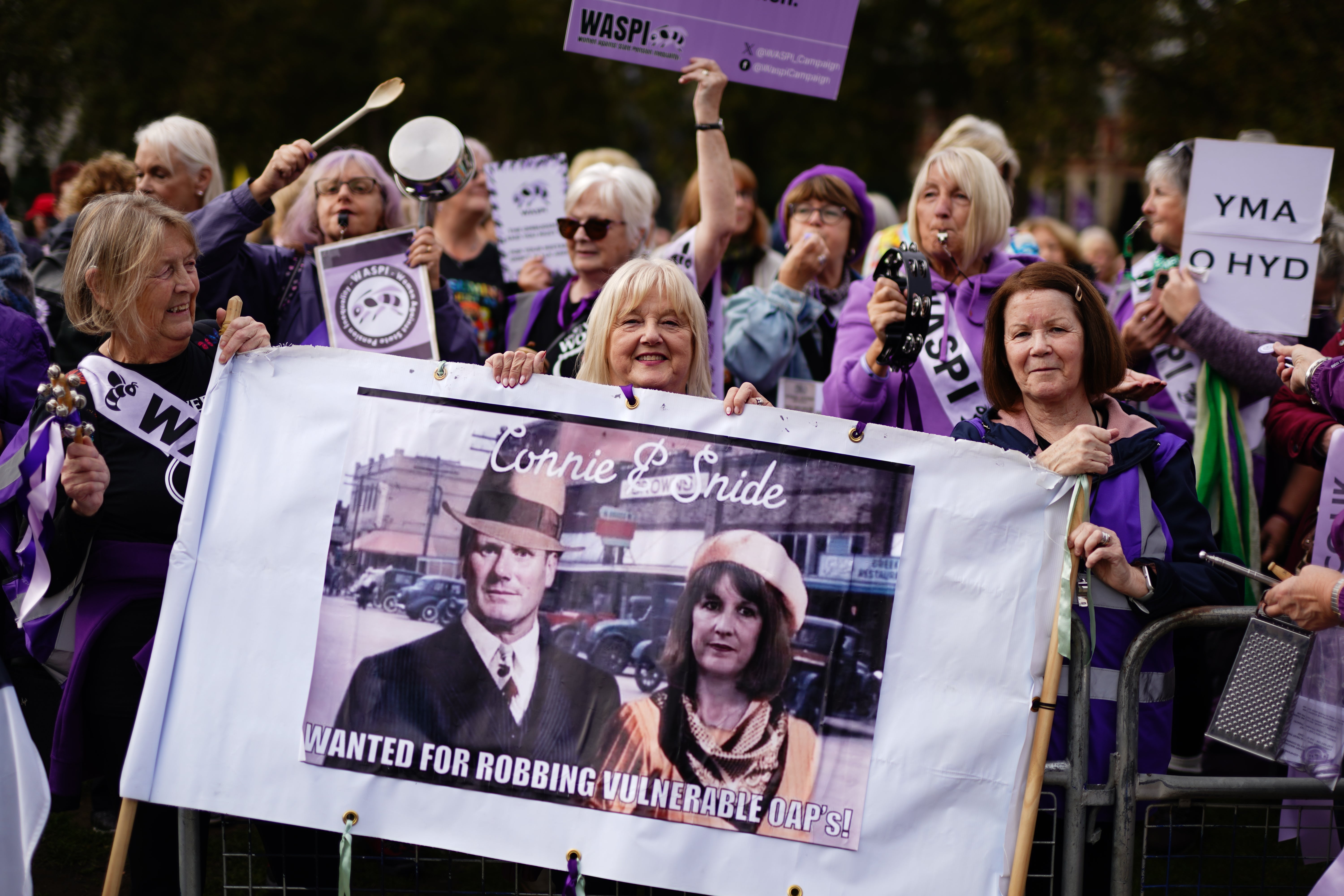 Waspi women protesting with a sign comparing the prime minister and chancellor to Bonnie and Clyde