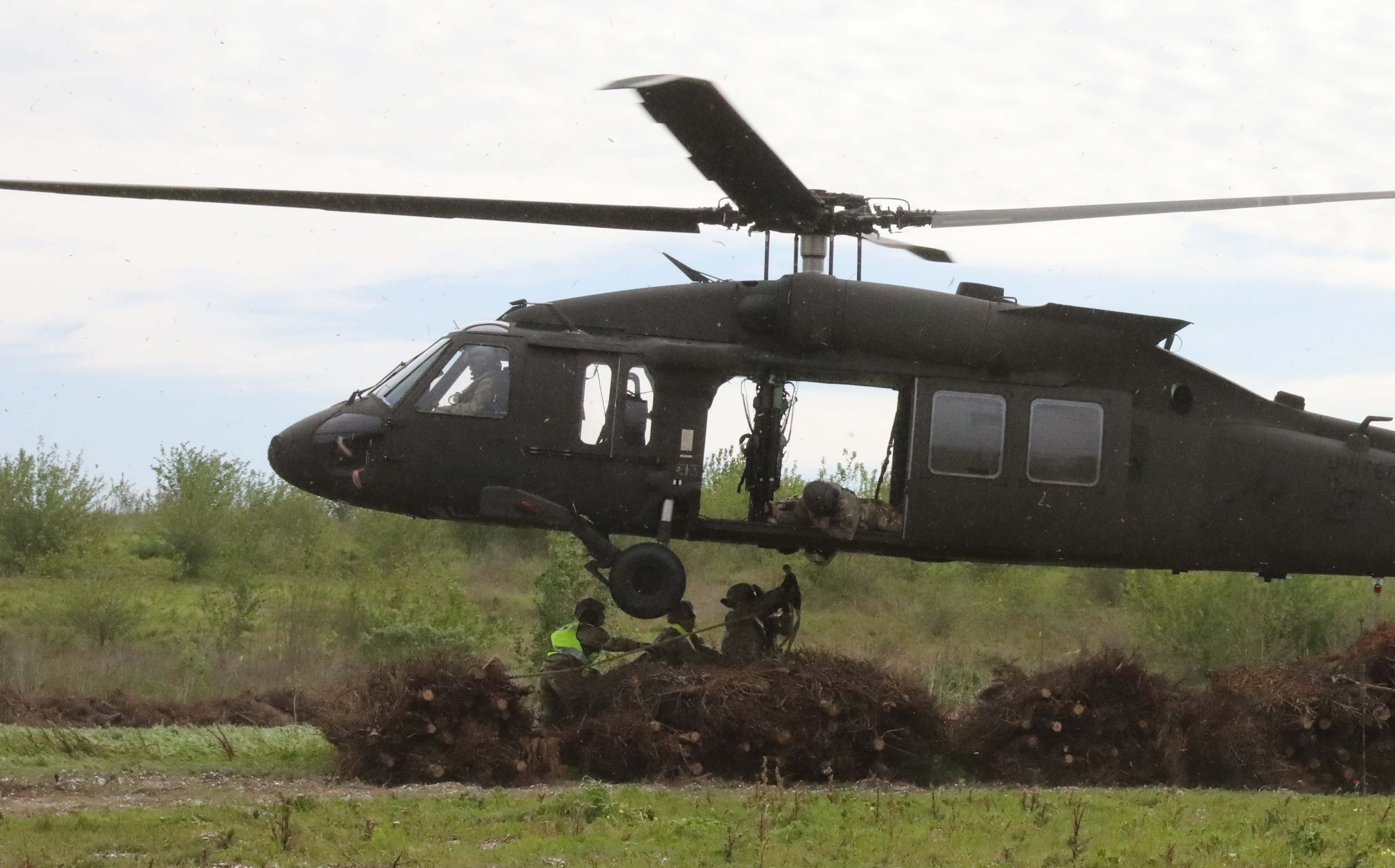 Christmas trees are dropped out of a Louisiana National Guard helicopter at the Bayou Sauvage National Wildlife Refuge. Thousands of the trees are included in the project