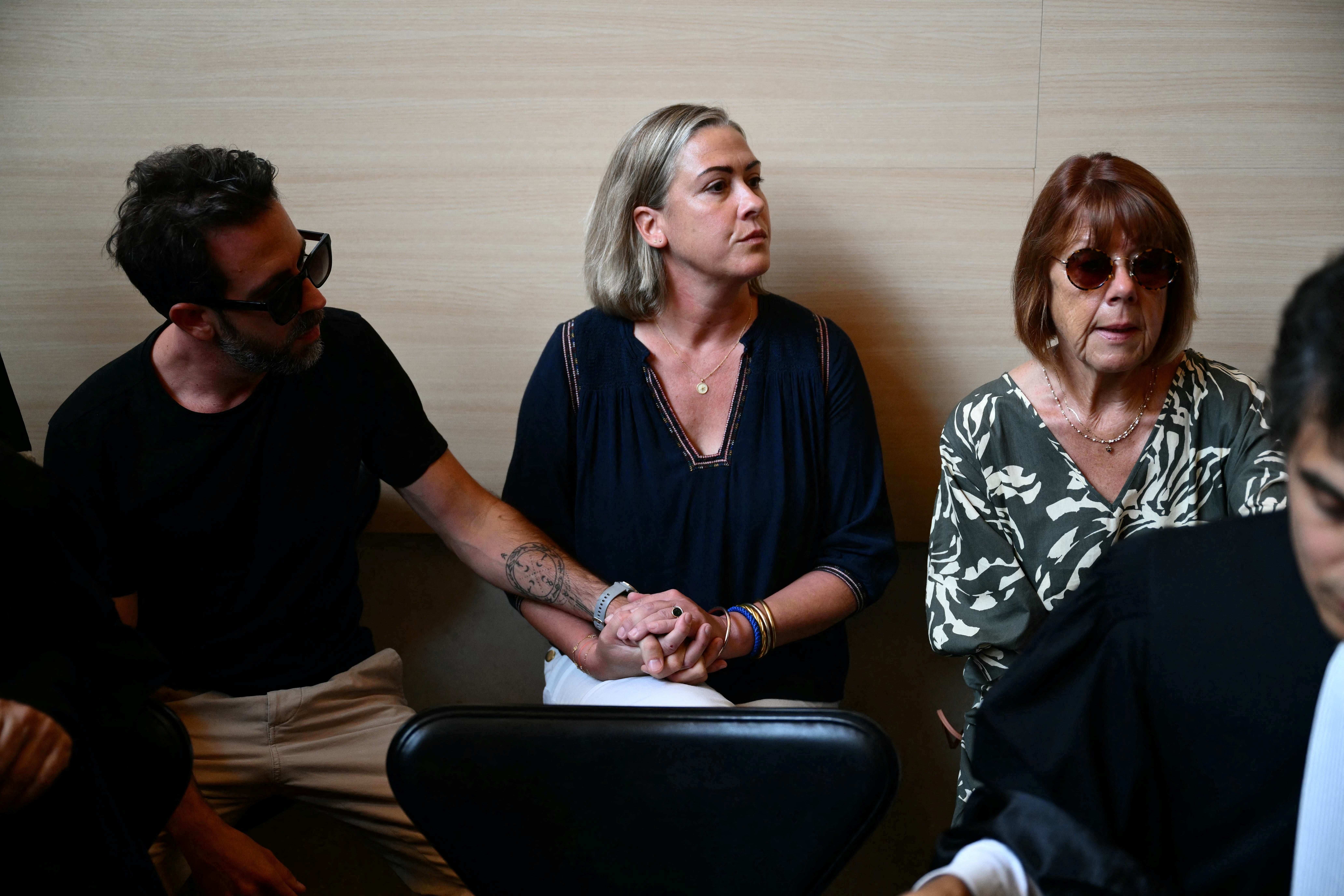 Gisele Pelicot (R) sits beside her daughter Caroline Darian (C) and her son (L) at the courthouse during the trial of her husband