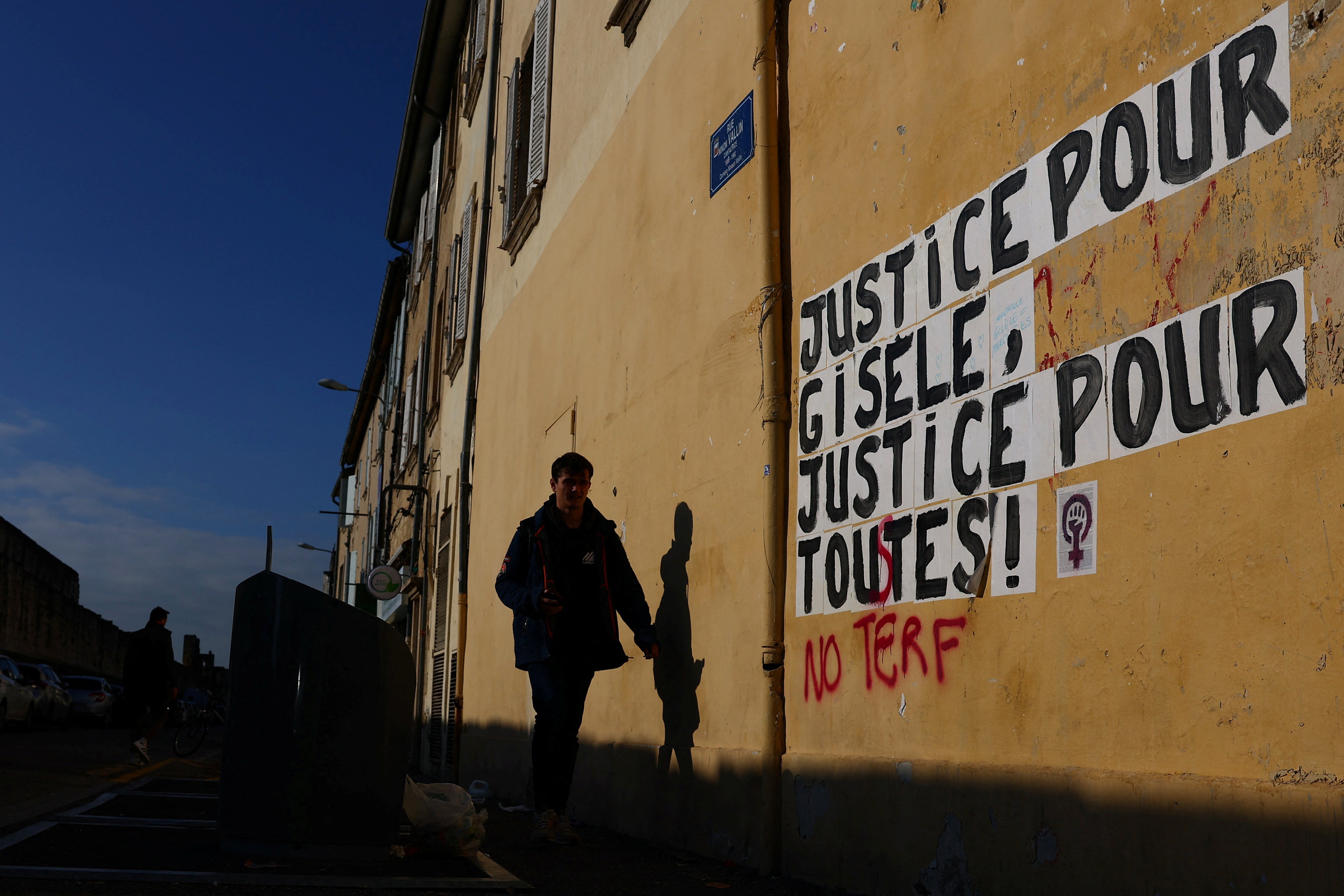 A man walks past the slogan which reads ‘Justice for Gisele, Justice for all’