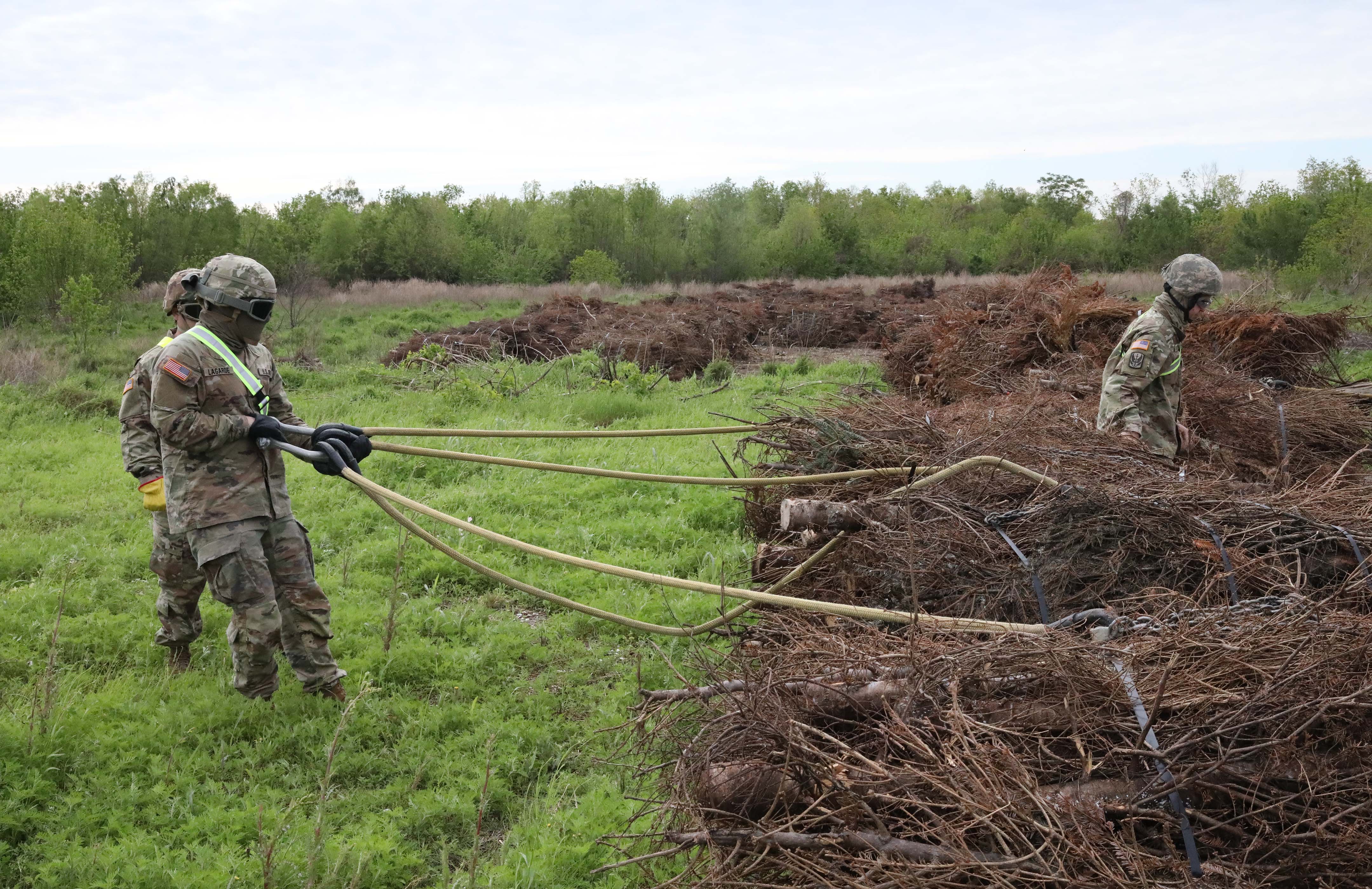 Louisiana National Guard members put Christmas trees on harnesses. The trees are bundled together using wire