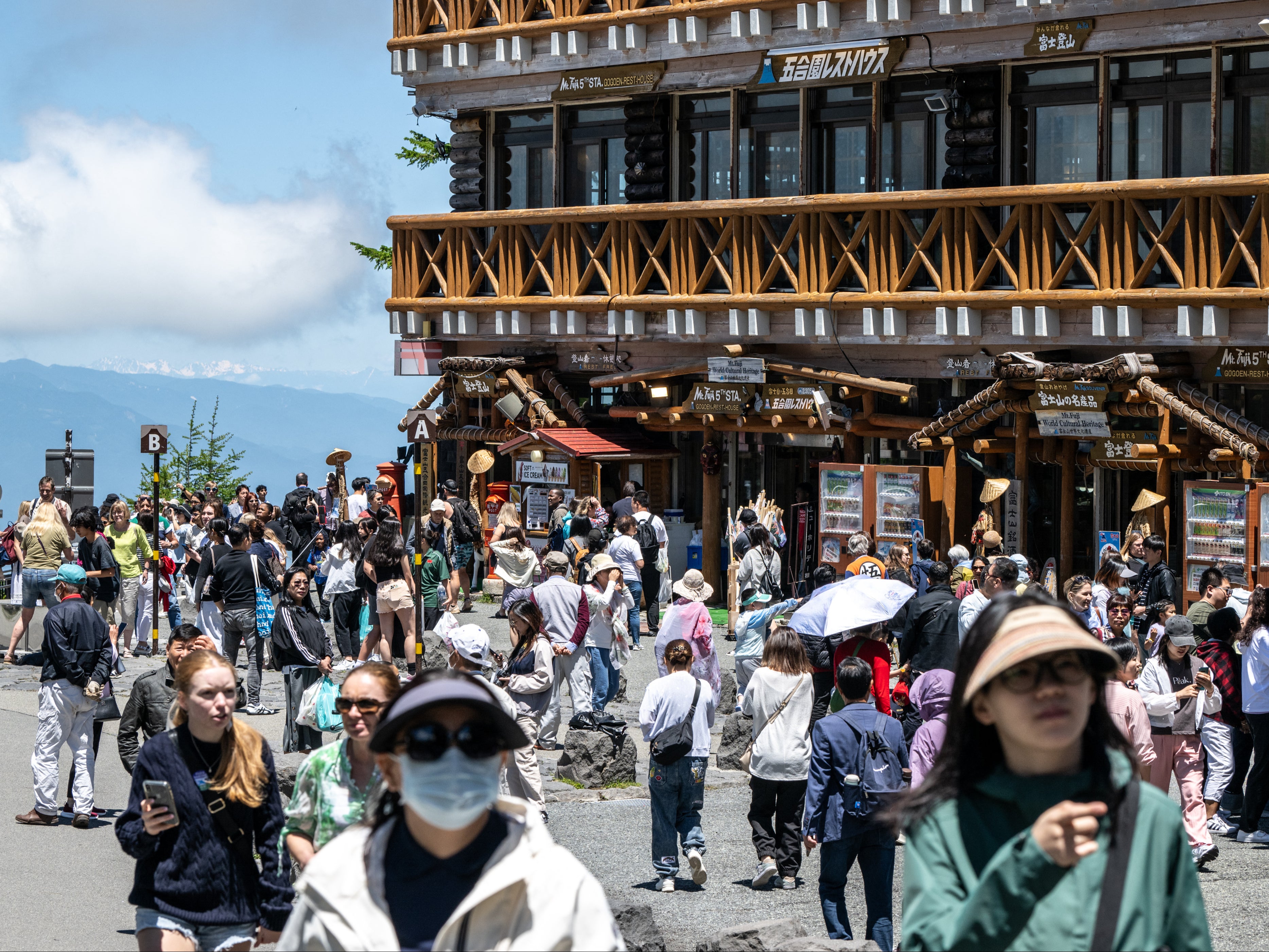 Tourists are seen at Fuji Subaru Line 5th station, which leads to the popular Yoshida trail for hikers climbing Mount Fuji, in Yamanashi Prefecture on 19 June 2024