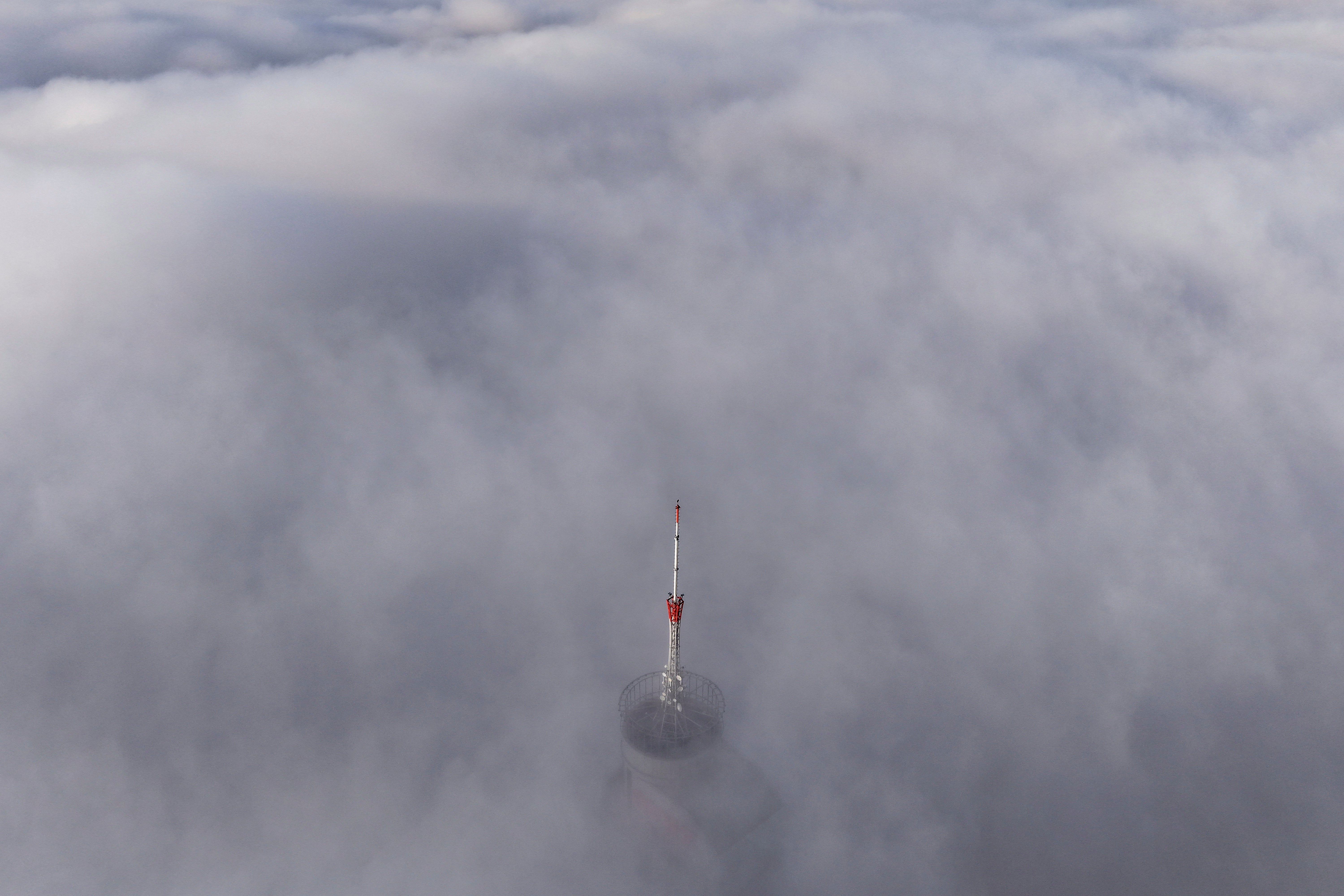 Avaz Twist Tower building, 172 meters high, peaks through a dense layer of fog and smog in Sarajevo