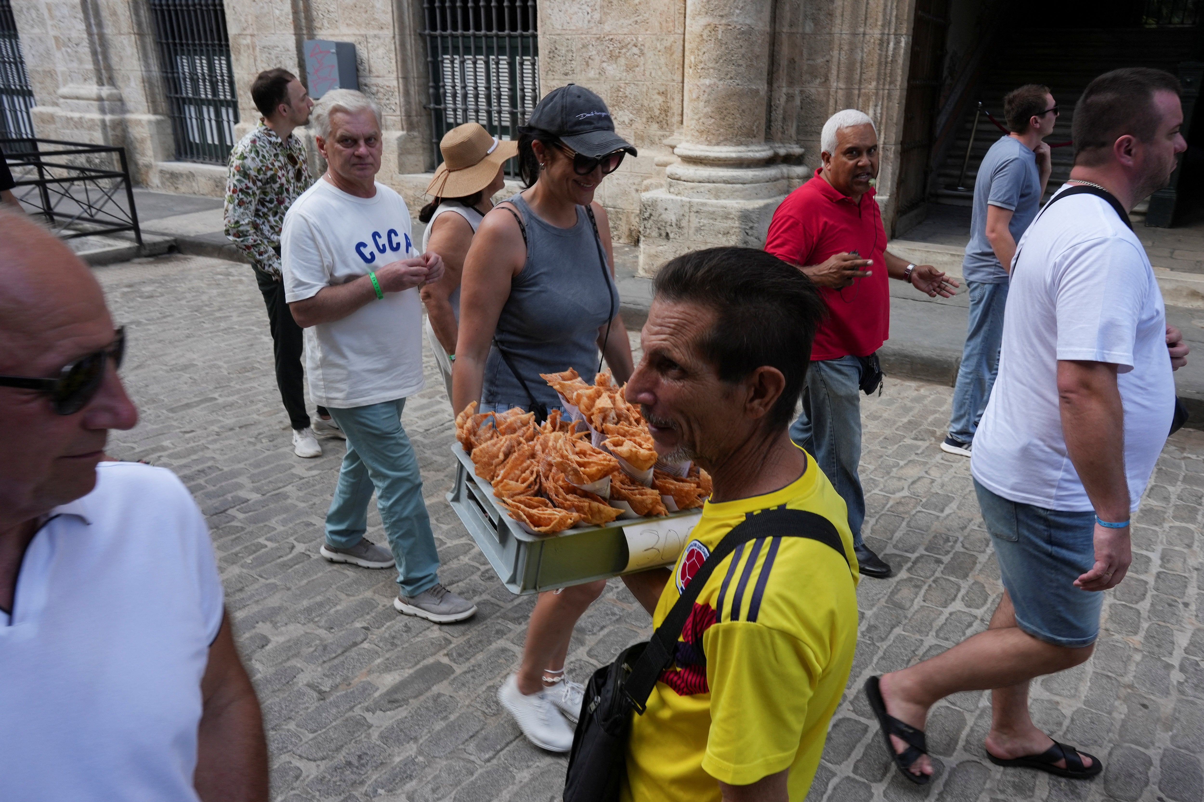 A man tries to sell snacks to tourists from Russia in downtown Havana, Cuba