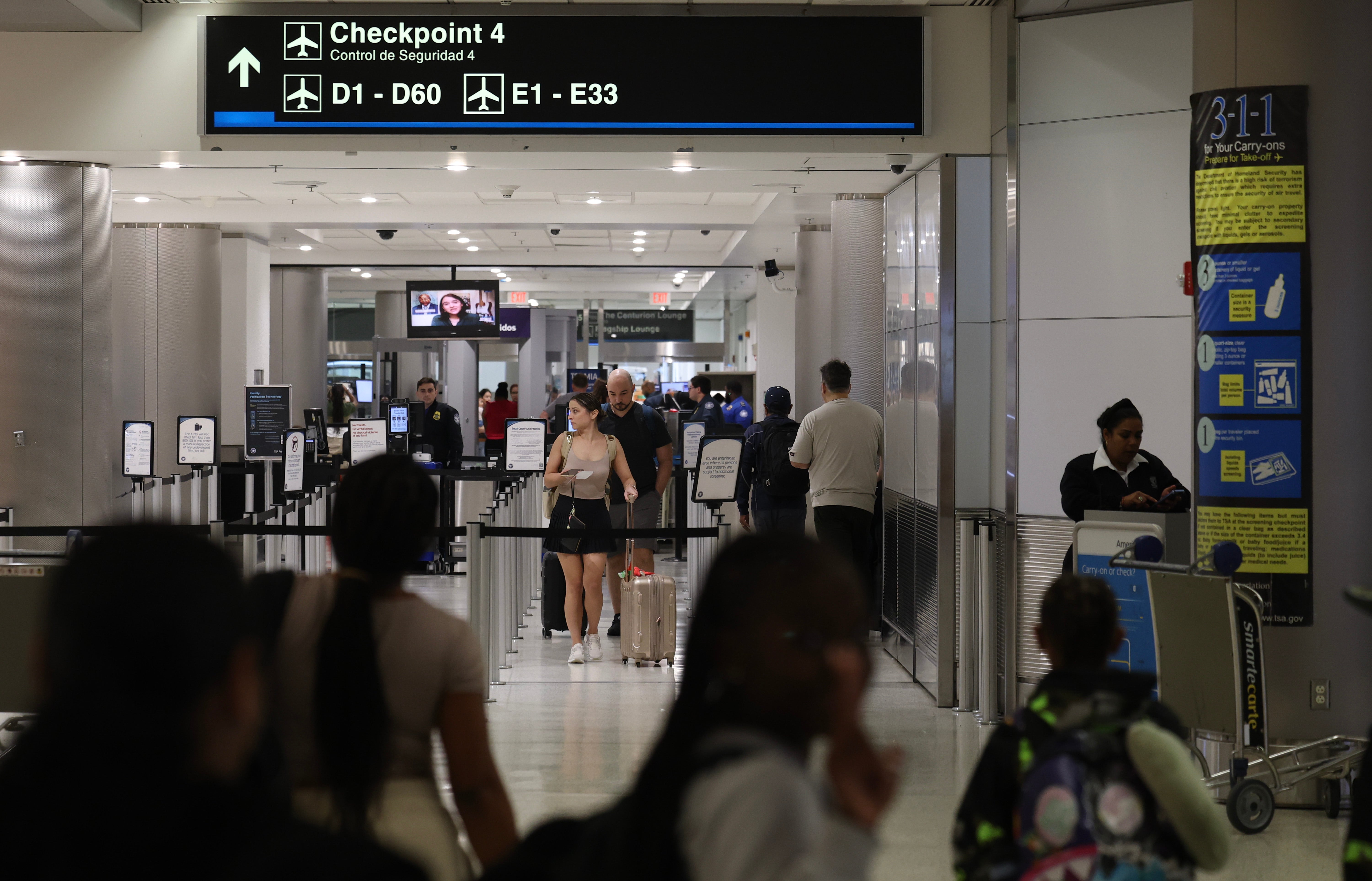 Passengers pass through the TSA checkpoint at Florida’s Miami International Airport on Tuesday. Nearly 120 million Americans are expected to travel for the holidays this month