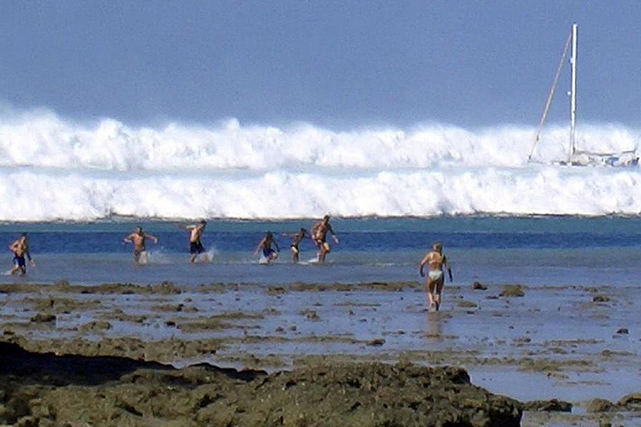 Tourists caught by the first of six tsunamis rolling towards Hat Railay Beach in Thailand