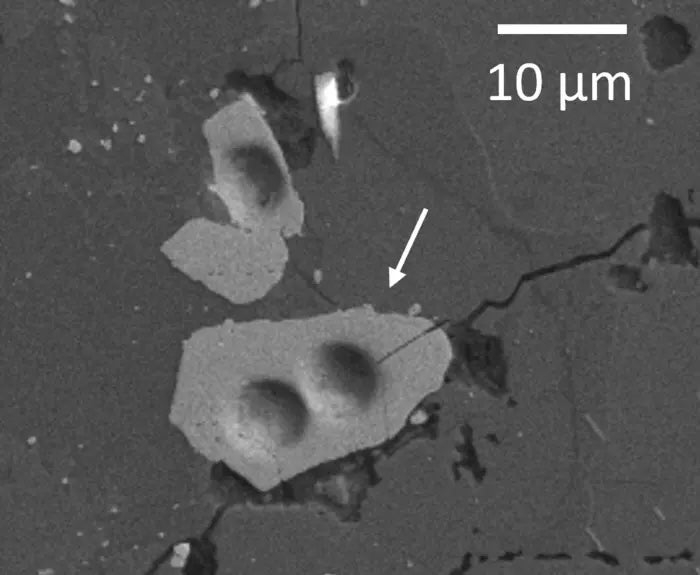 A lunar zircon grain is seen under a microscope. The mineral crystals were used in previous research estimating that the moon was tens of millions of years older than previously believed