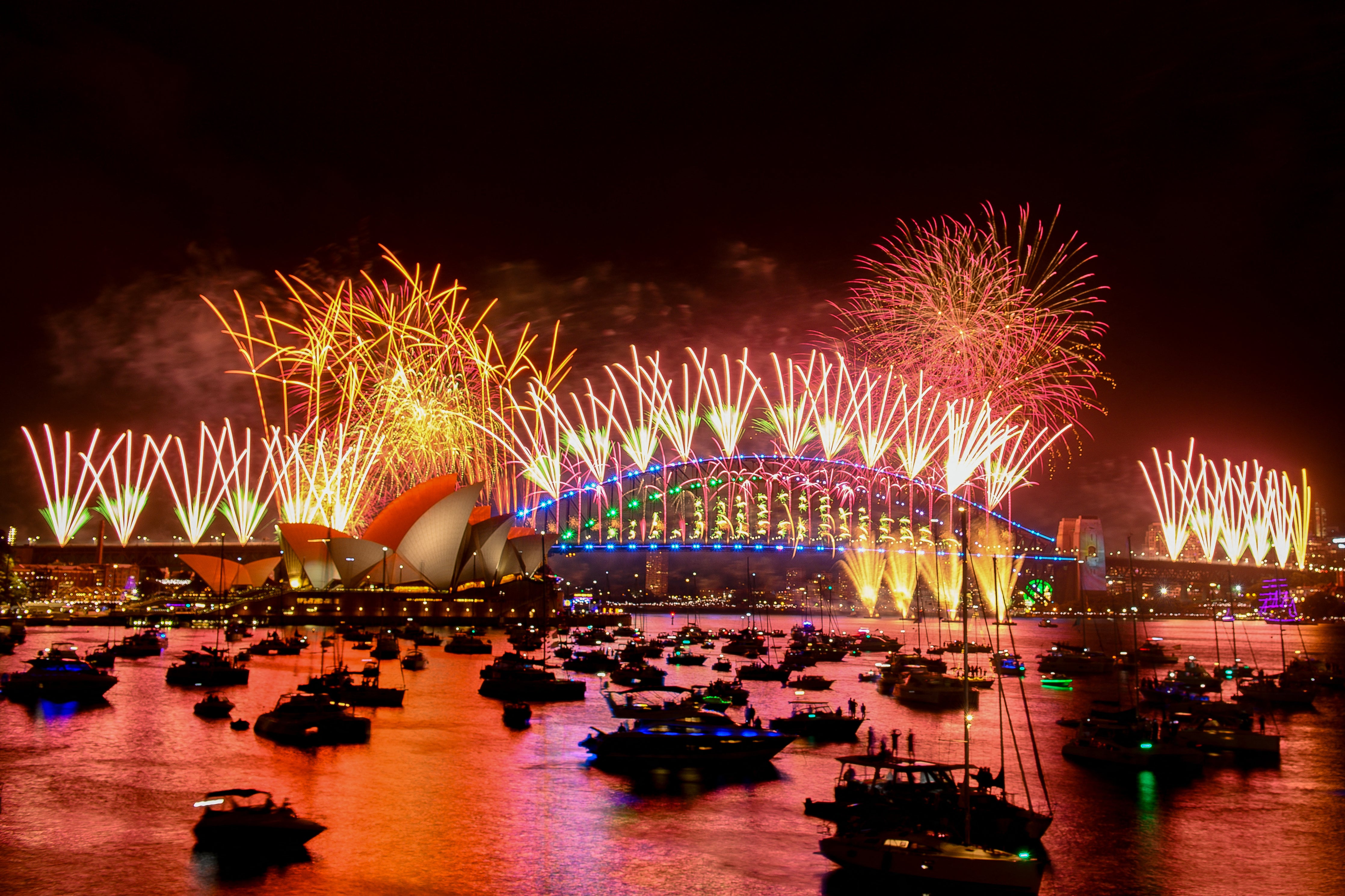 Fireworks explode over the Sydney Harbour Bridge and Sydney Opera House (L) during New Year’s Eve celebrations in Sydney on 1 January 2024