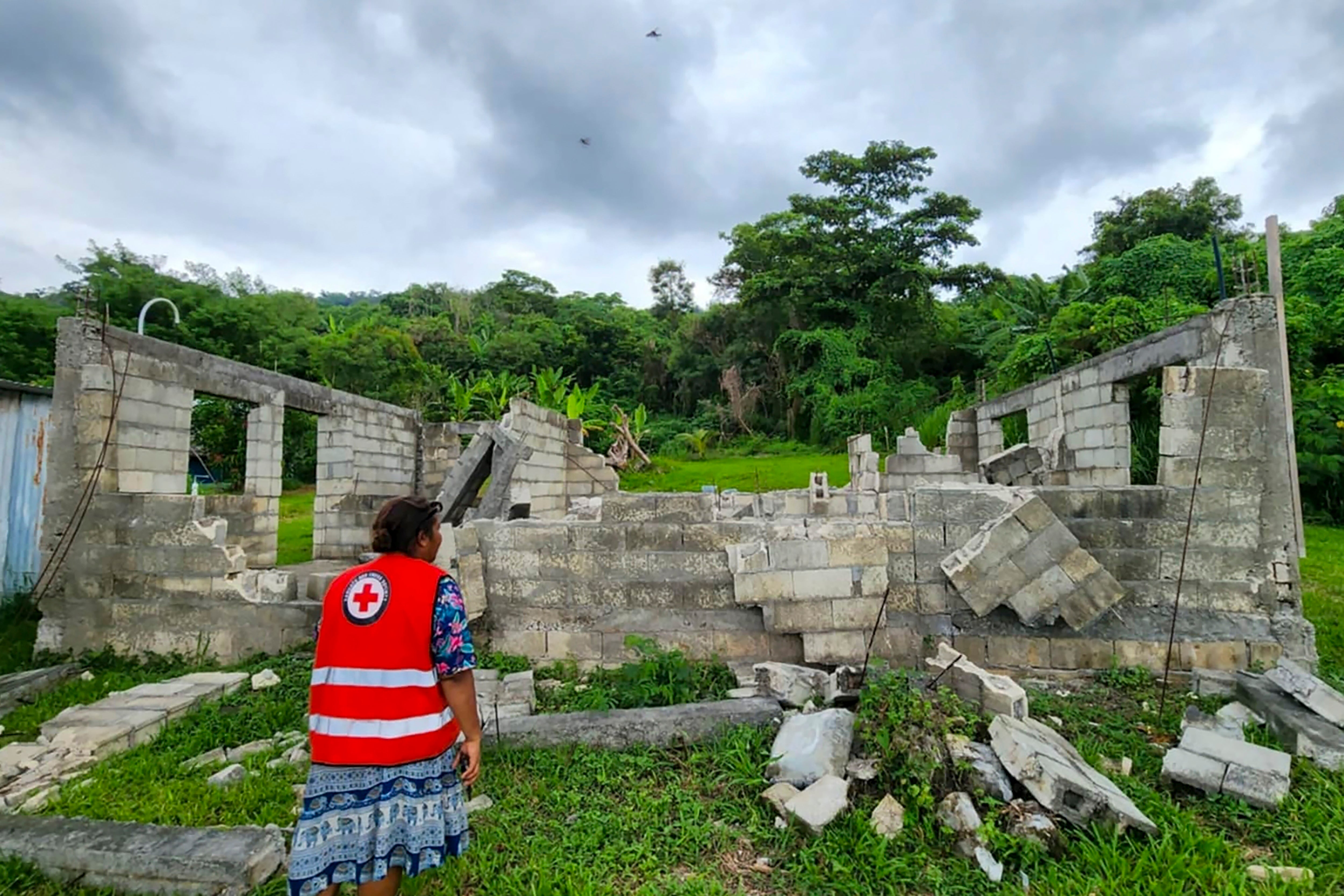 In this photo released by the Vanuatu Red Cross Society, a Red Cross volunteer inspects a damaged house in Efate, Vanuatu, Thursday, 19 December 2024, following a powerful earthquake that struck just off the coast of Vanuatu in the South Pacific Ocean