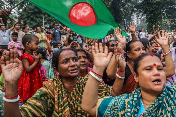 People take part in a protest march in Dhaka