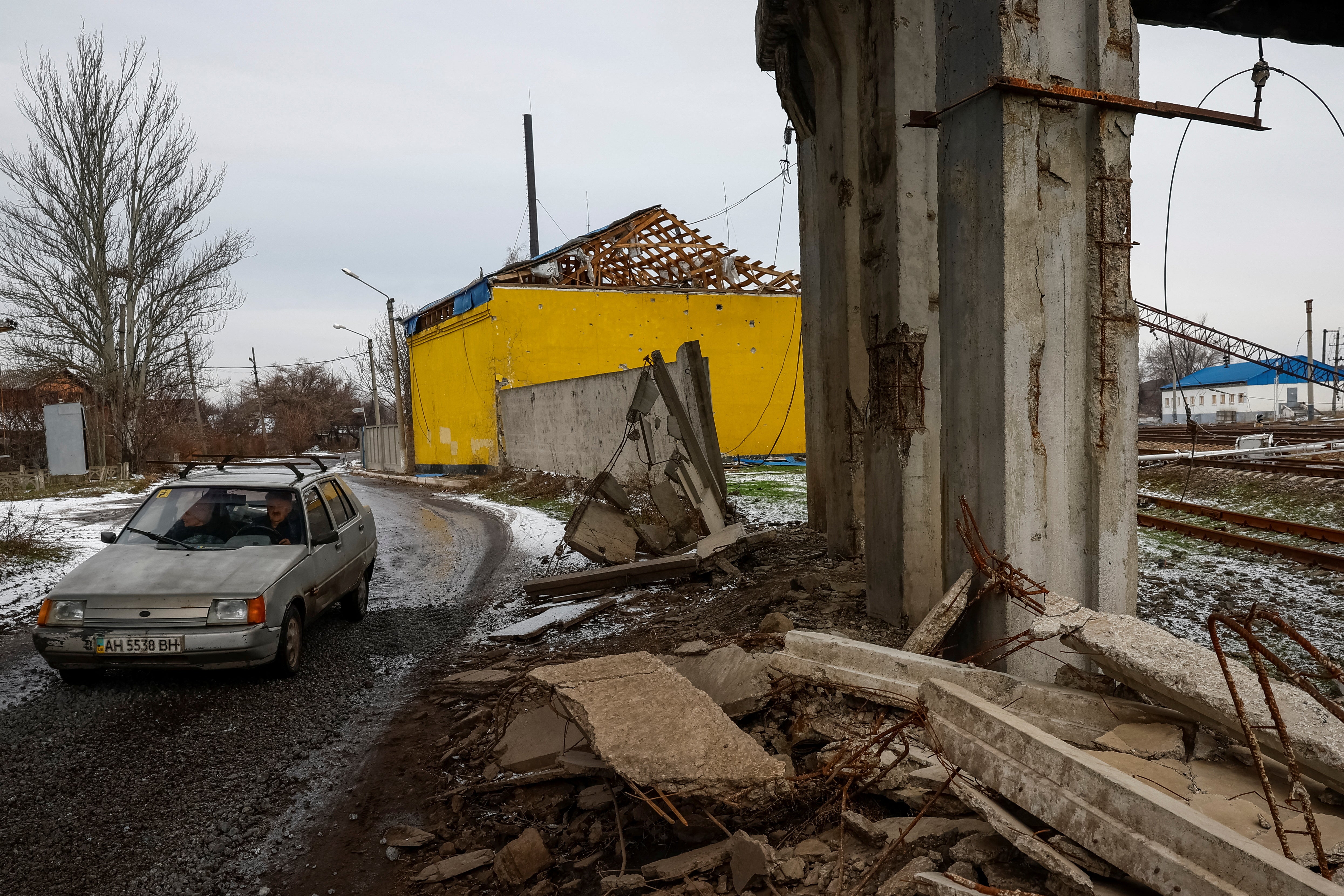 Local residents drive by a destroyed bridge, amid Russia's attack on Ukraine, in the town of Pokrovsk, near a front line in Donetsk region