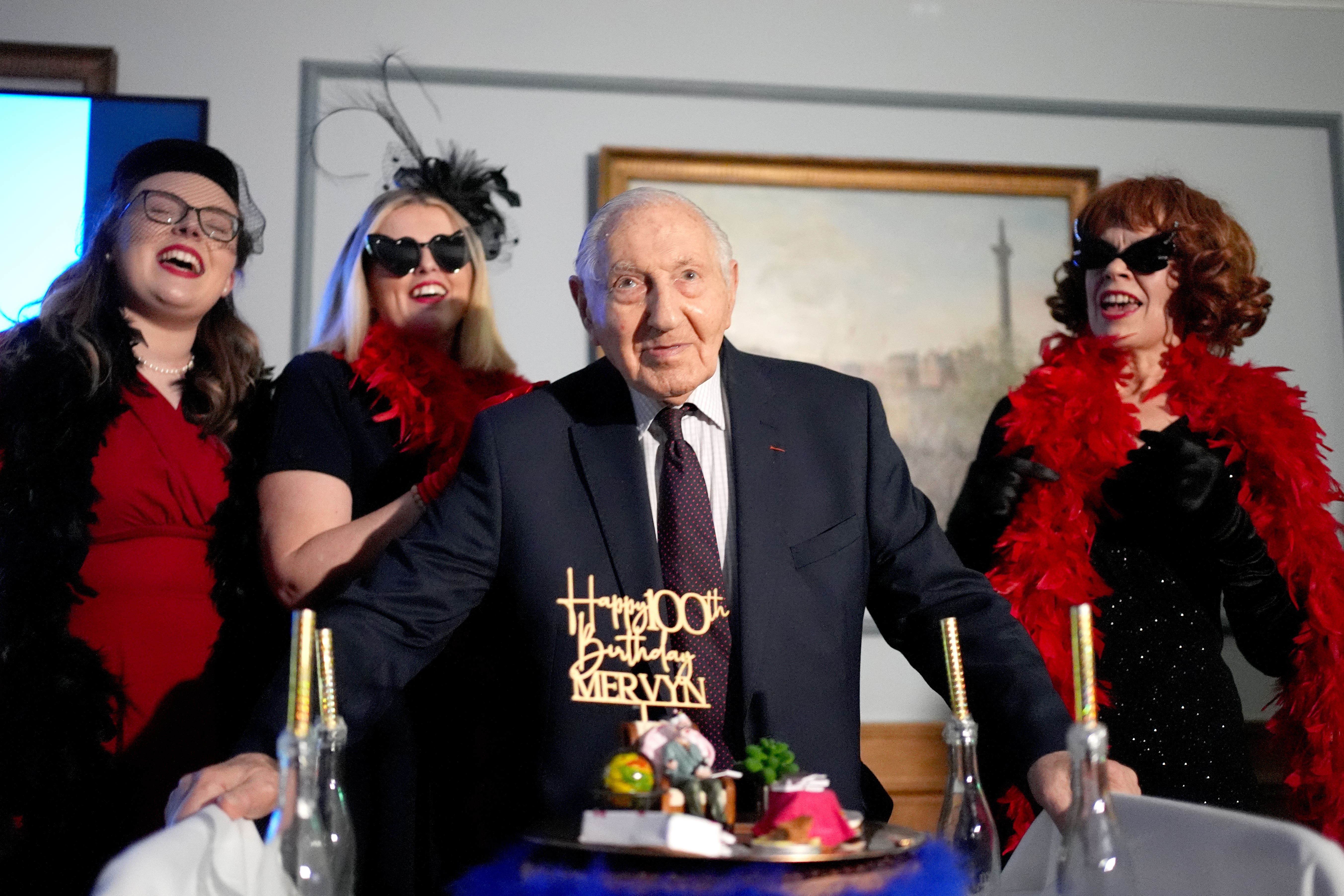 The Taxiettes sing happy birthday to Normandy veteran Mervyn Kersh during a surprise party for his 100th birthday at the Union Jack Club in London (Jordan Pettitt/PA)