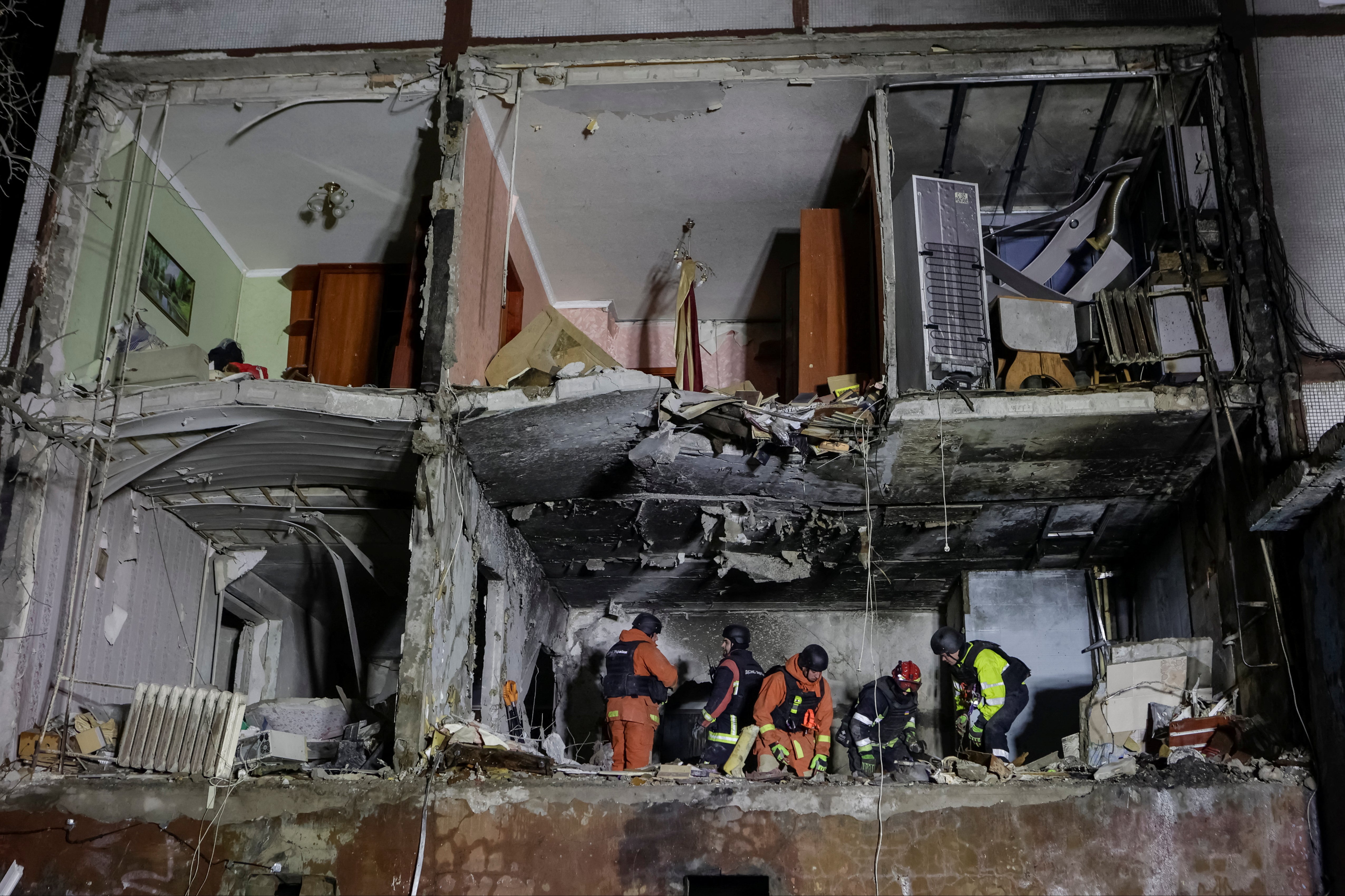 Rescuers at work in the remains of an apartment building damaged by a Russian drone strike in Kharkiv