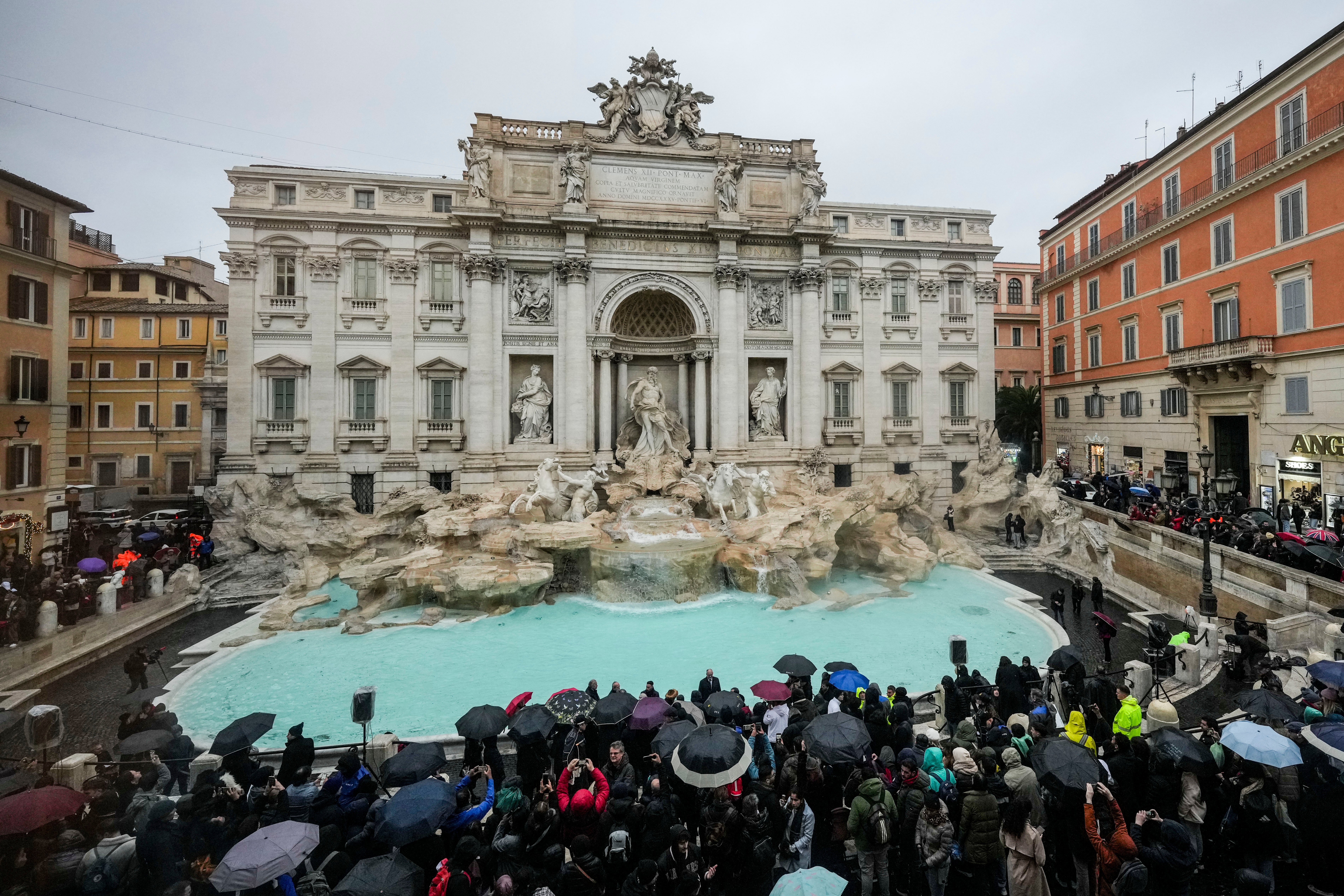 People admire the 18th century Trevi Fountain, one of Rome’s most iconic landmarks