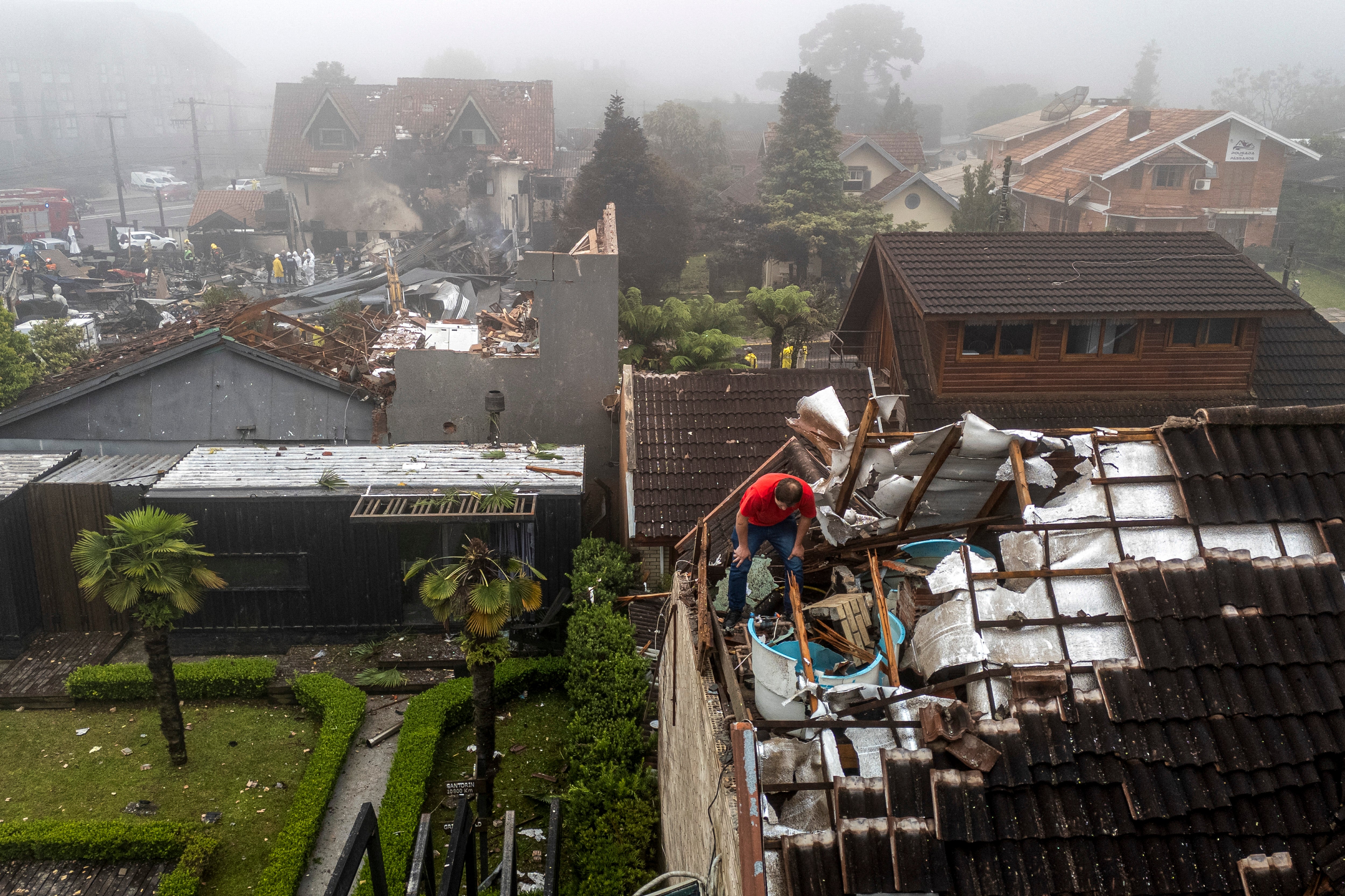 A man checks the damages on a roof caused by a plane crash at the city of Gramado, Rio Grande do Sul state, Brazil