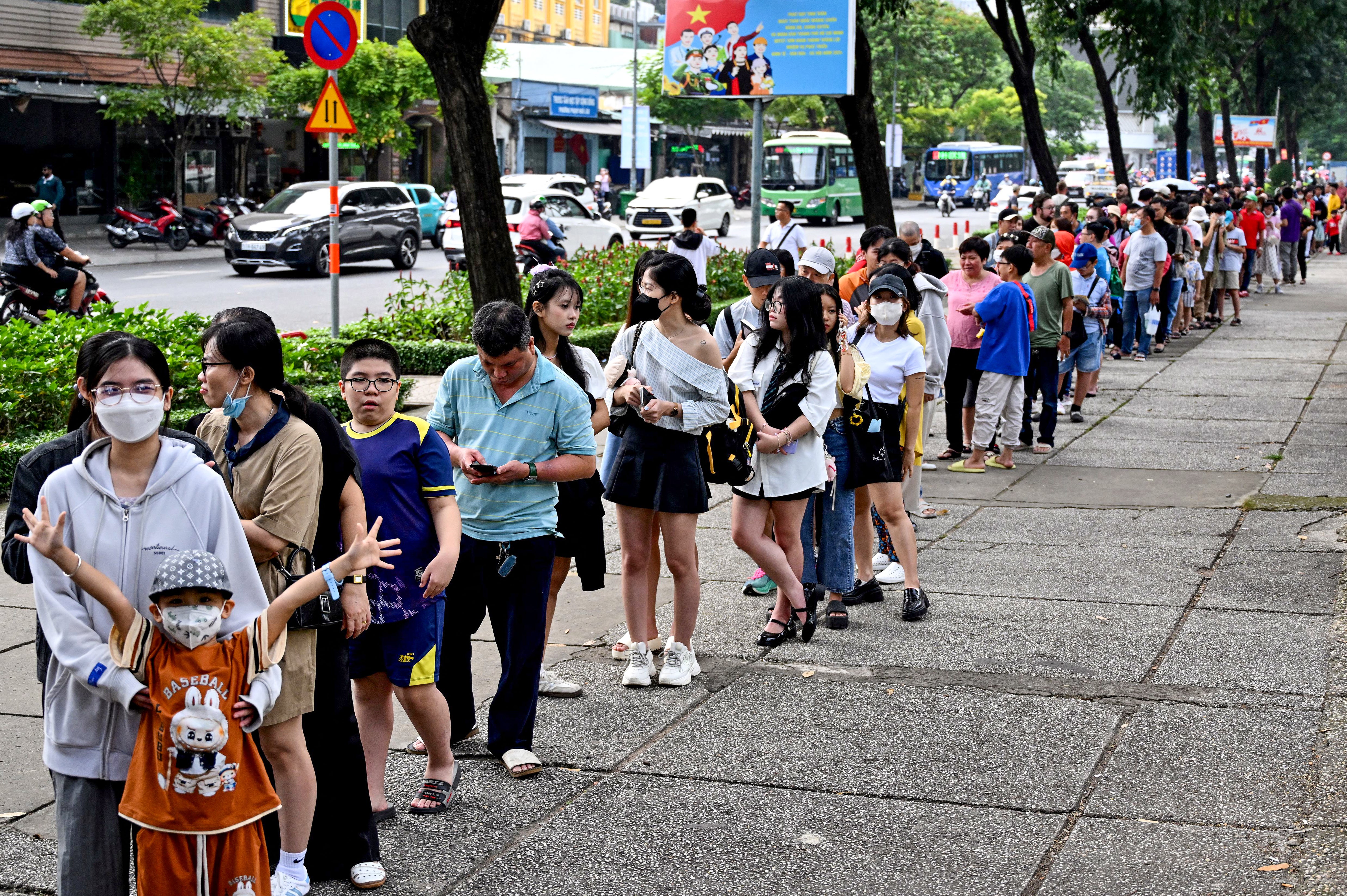 People line up as they arrive at a metro station in Ho Chi Minh City