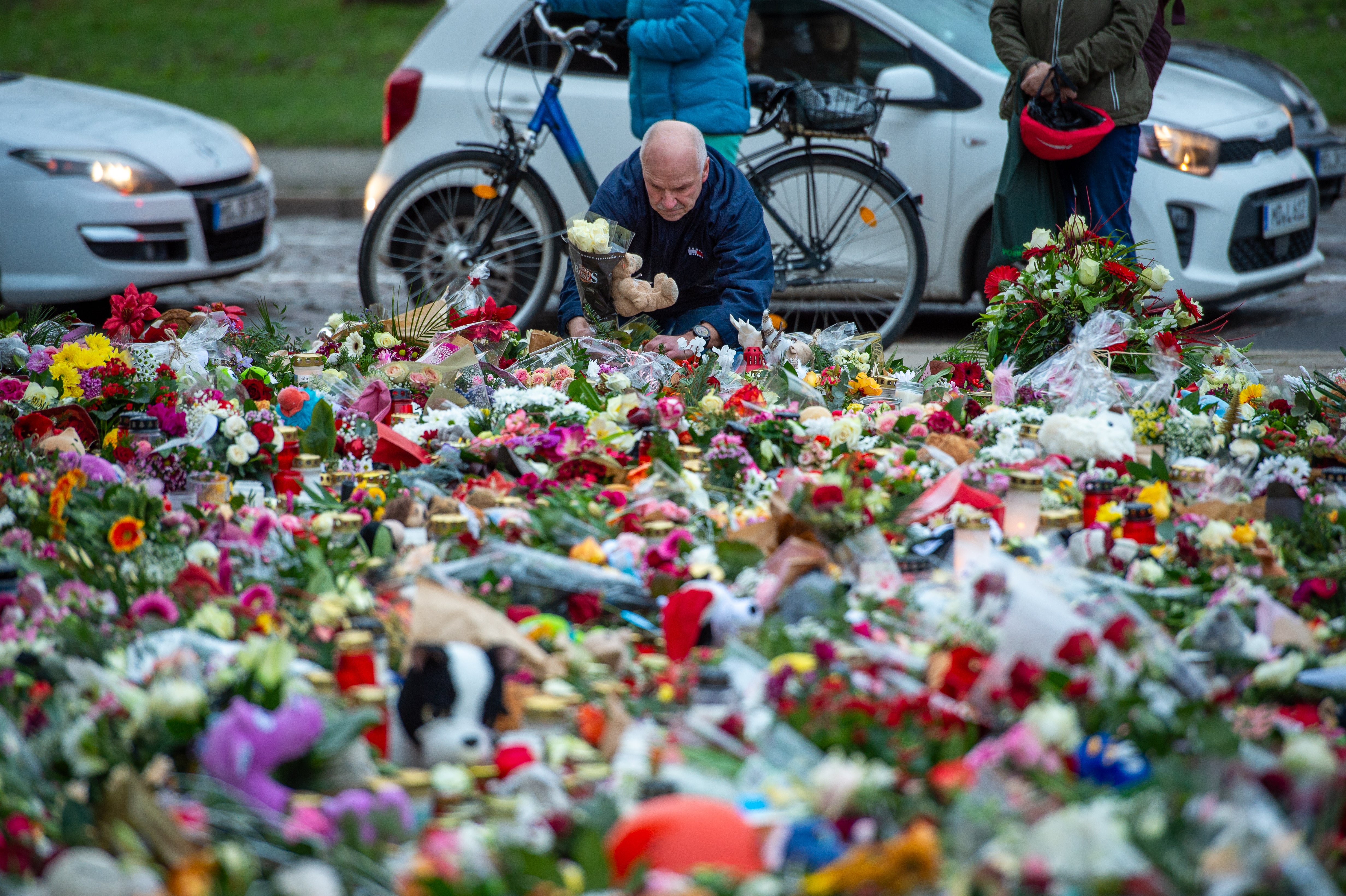 A member of the public laying flowers at a memorial for the victims