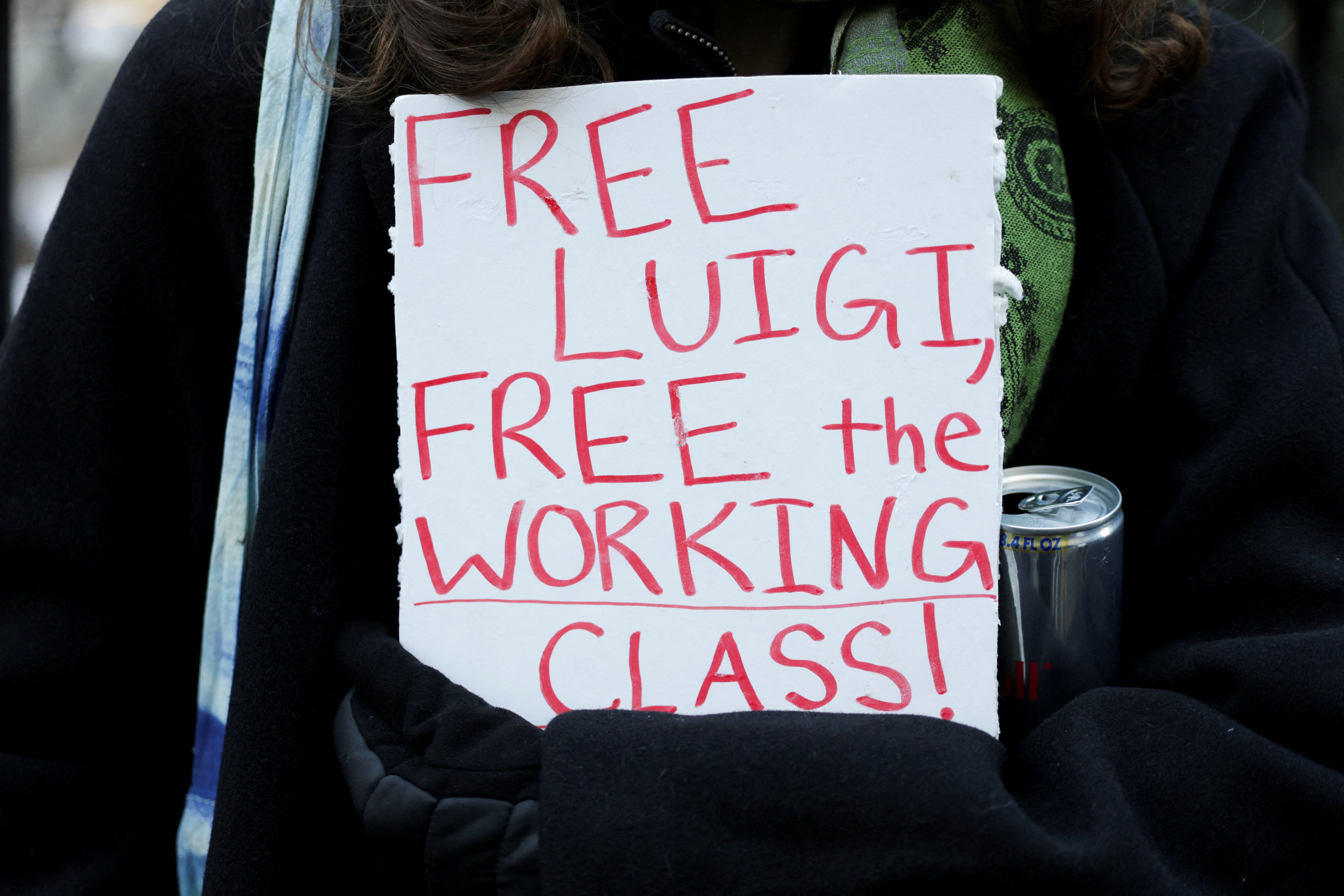A Luigi Mangione supporter holding a sign outside his arraignment hearing in New York City on December 23, 2024