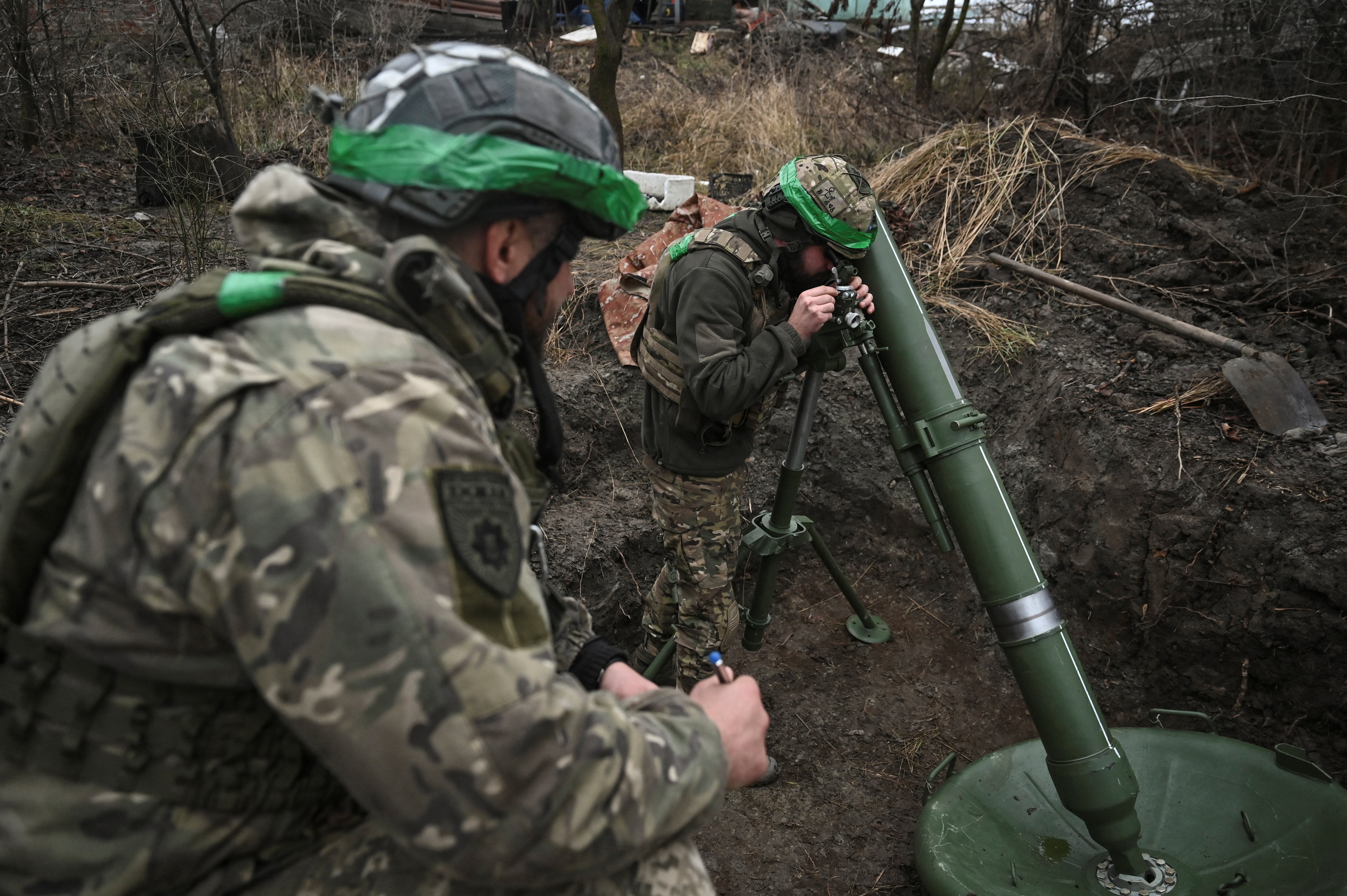 Ukrainian troops prepare to fire a mortar towards Russian troops