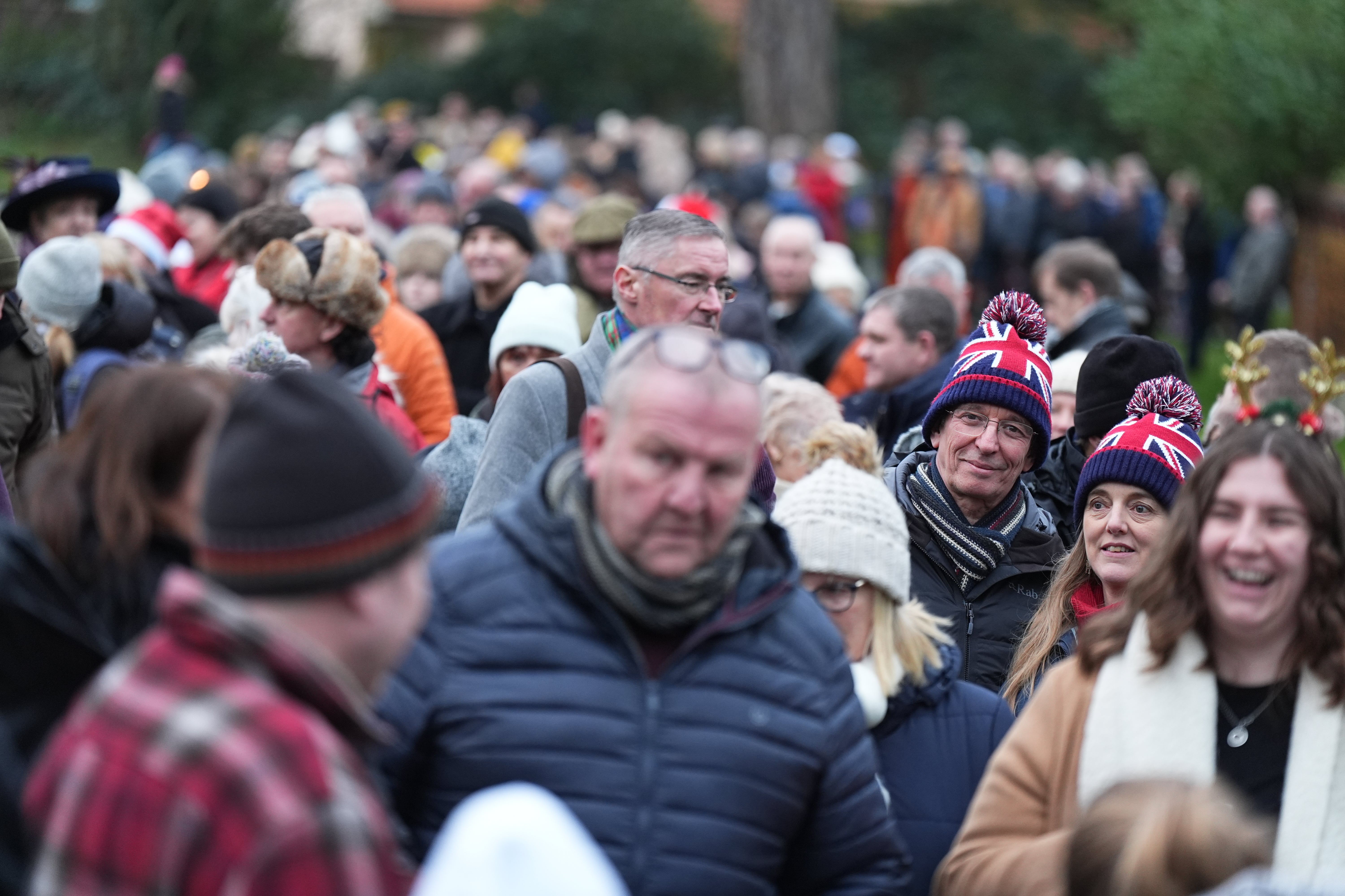 Royal fans gather outside the Sandringham estate to wait for the King and Queen