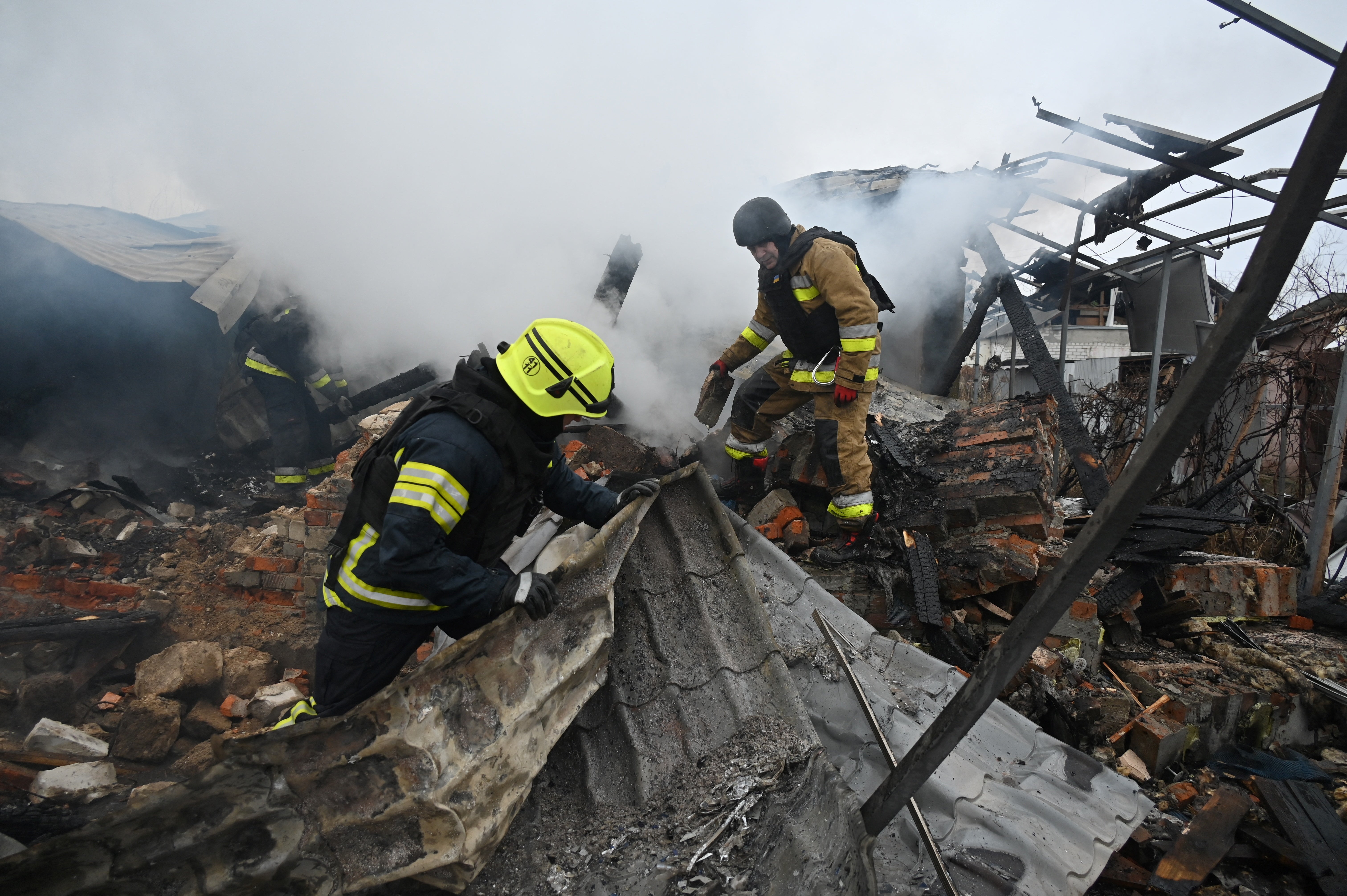 Rescuers of Ukraine’s State Emergency Service work to put out a fire in a private house after a drone strike in Kharkiv