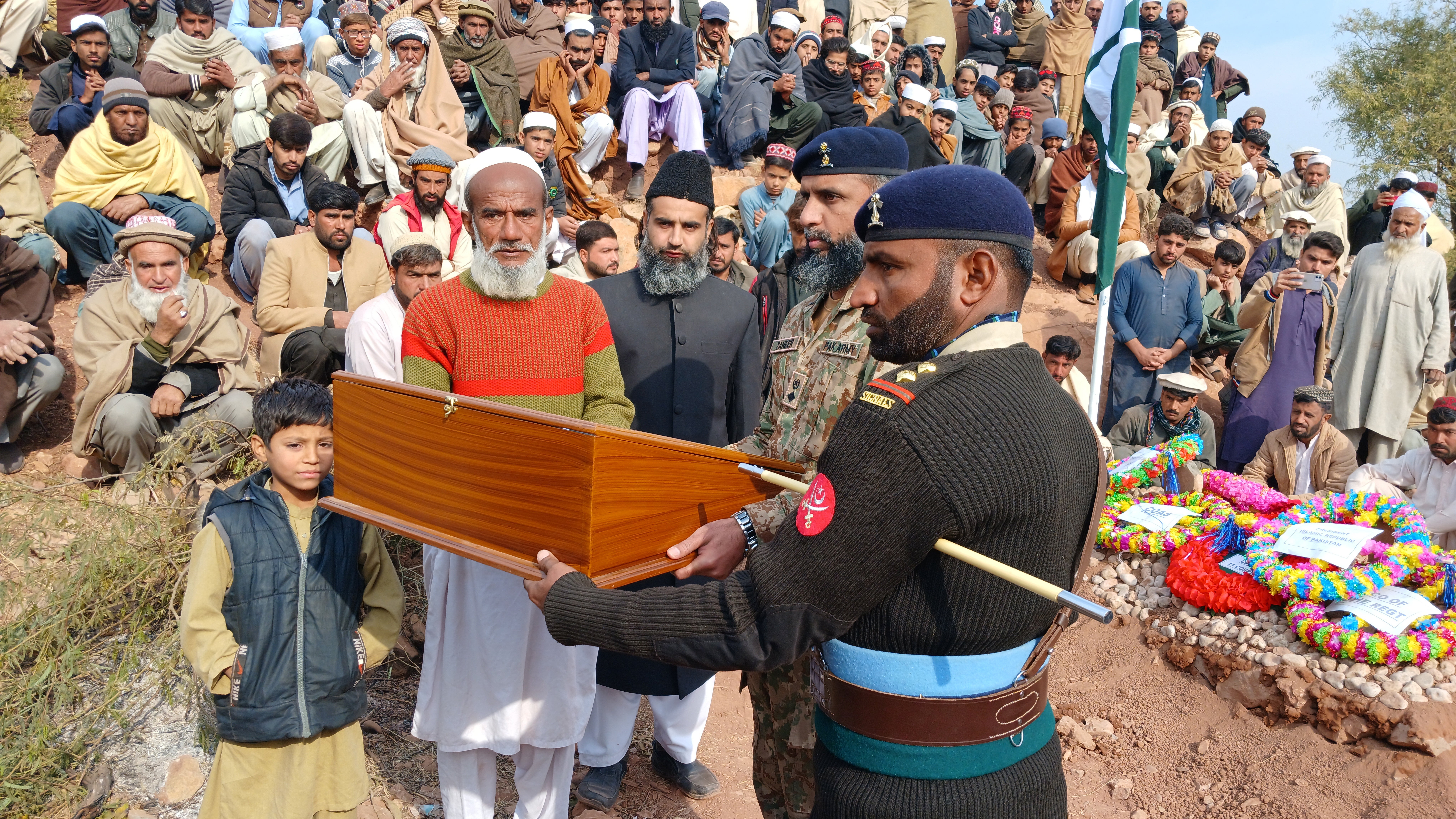 Pakistani Army soldiers give a uniform and national flag to the father of soldier Umar Hayat, one of the 16 soldiers killed in a militant attack at a checkpoint in the Makeen area of the Upper South Waziristan district