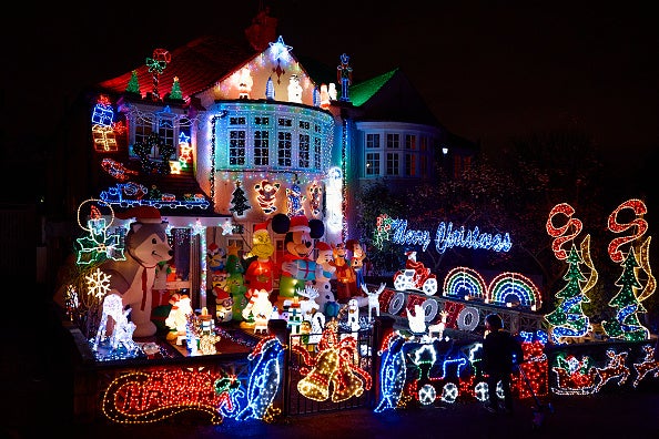 A child looks at a house decorated with Christmas lights in North London