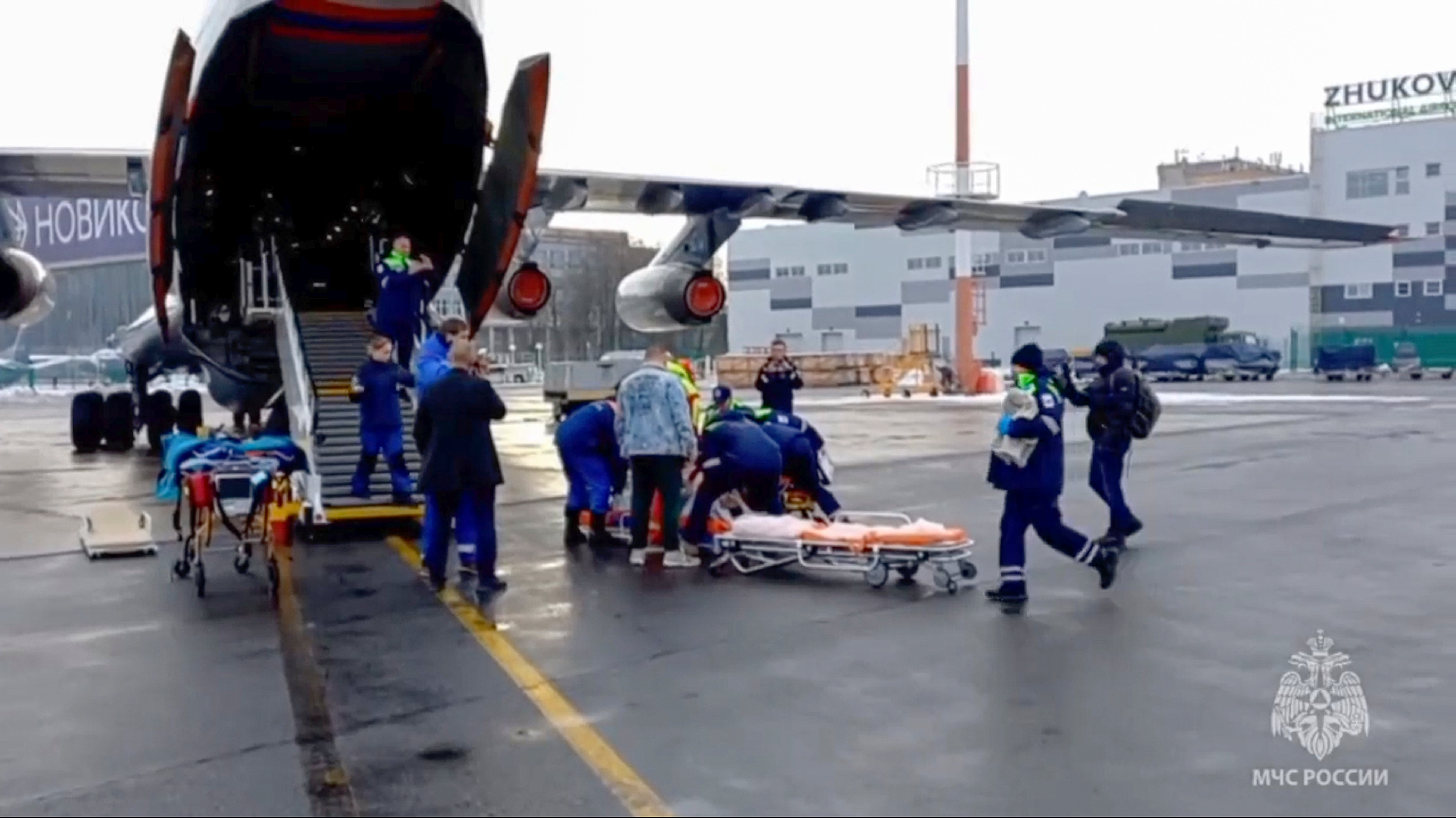 Rescuers transport wounded passengers from a medical plane after the crash