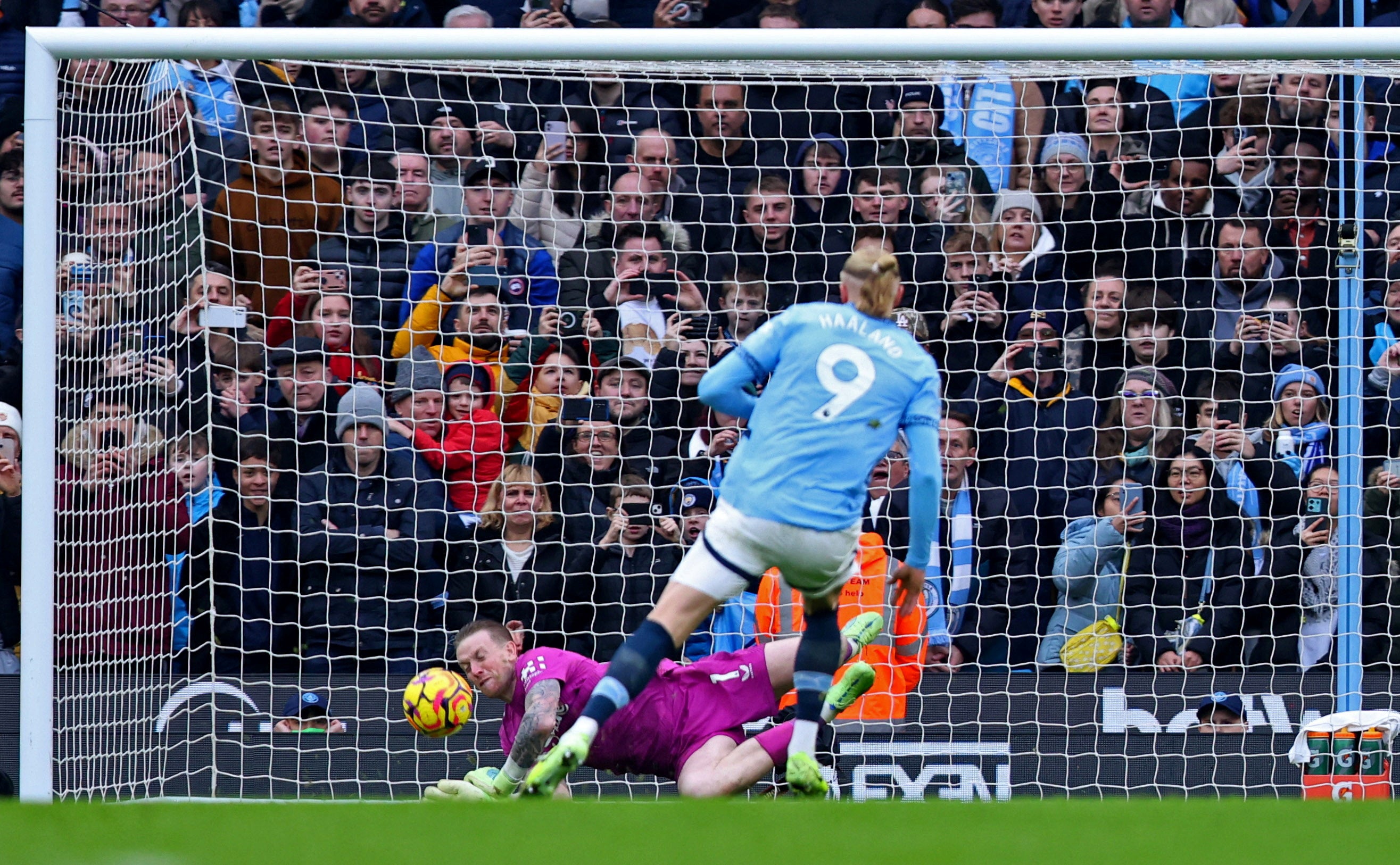 Jordan Pickford dives to his right to stop Erling Haaland’s penalty