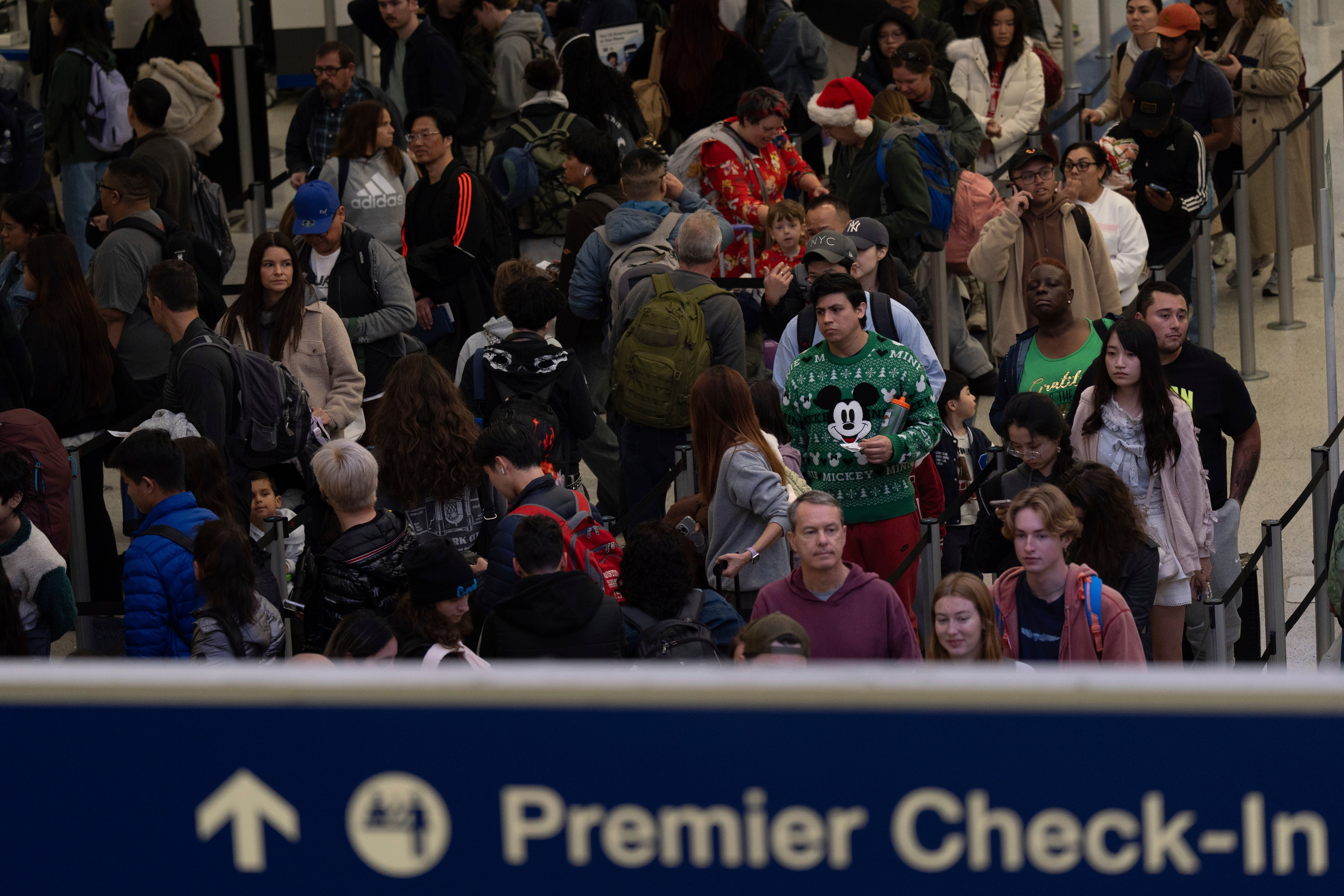 Travelers wait in line for security checks at the Los Angeles International Airport in Los Angeles, California, on Tuesday. Severe weather could cause major delays on Thursday and Friday