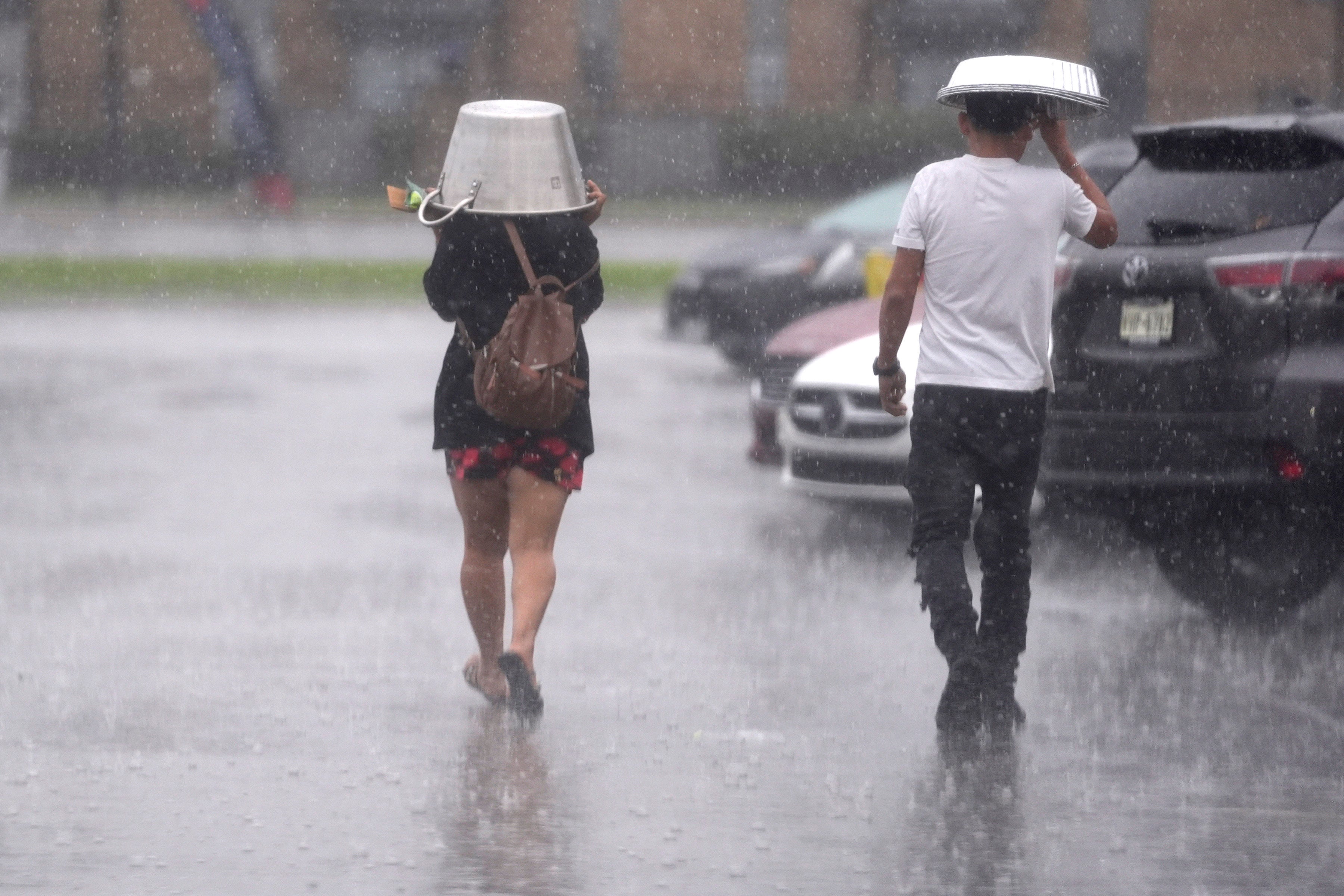 People cover up from falling rain on Tuesday in Dallas, Texas. Texas and the Gulf Coast will see heavy rain and thunderstorms this week