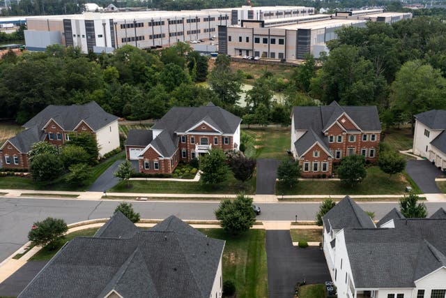 <p>An Amazon Web Services data center is seen close to homes in Stone Ridge, Virginia, last July. New research is highlighting the health costs of new data centers being built across the U.S. </p>