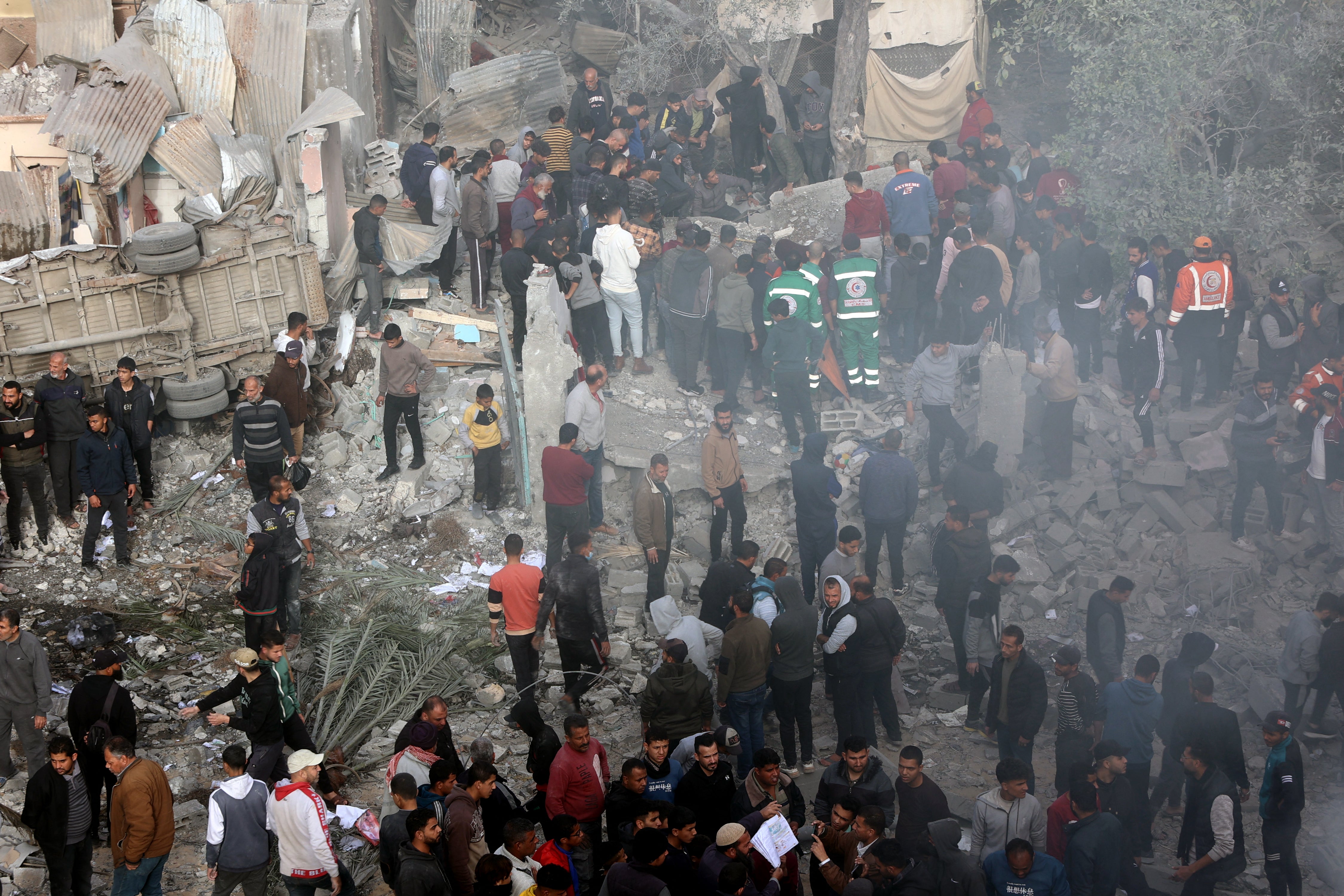 Rescuers and civilians stand at the site of an Israeli strike in a residential area in the Tuffah neighbourhood east of Gaza City on 26 December 2024