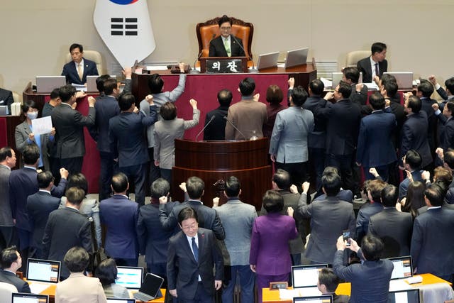 <p>Democratic Party leader Lee Jae Myung, bottom centre, walks past lawmakers of the ruling People Power Party protesting to National Assembly speaker Woo Won Shik, top centre, during a plenary session for the impeachment motion against acting president Han Duck Soo</p>