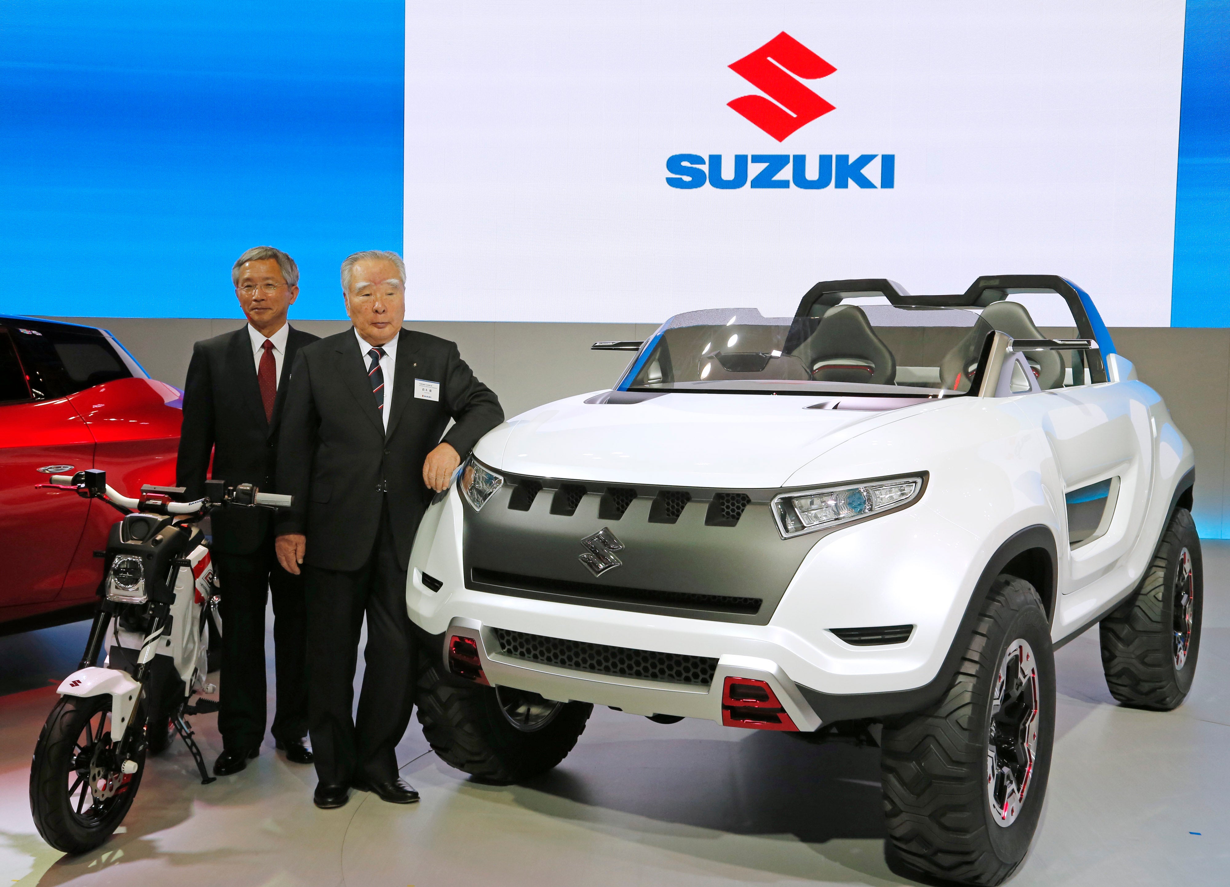 Osama Suzuki, right, and vice president Osamu Honda pose with a Suzuki X Lander hybrid concept car