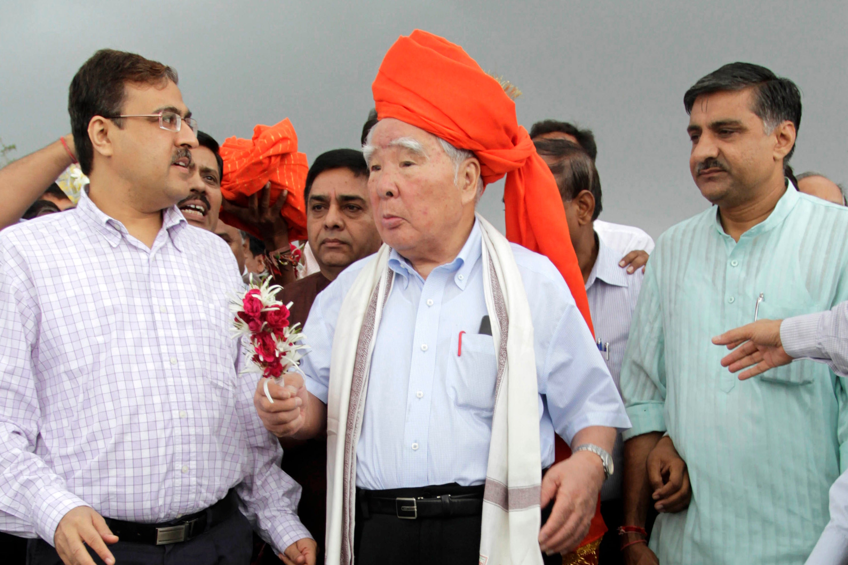 Osamu Suzuki receives a traditional welcome during his visit to the proposed site for a Maruti Suzuki India Ltd manufacturing facility at Hansalpur near Mehsana in Gujarat, India, on 25 August 2012