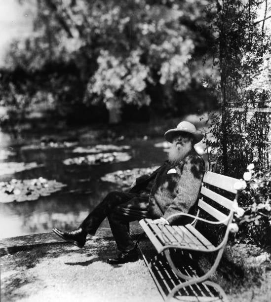 Claude Monet beside the water lily pond in his home garden in Giverny