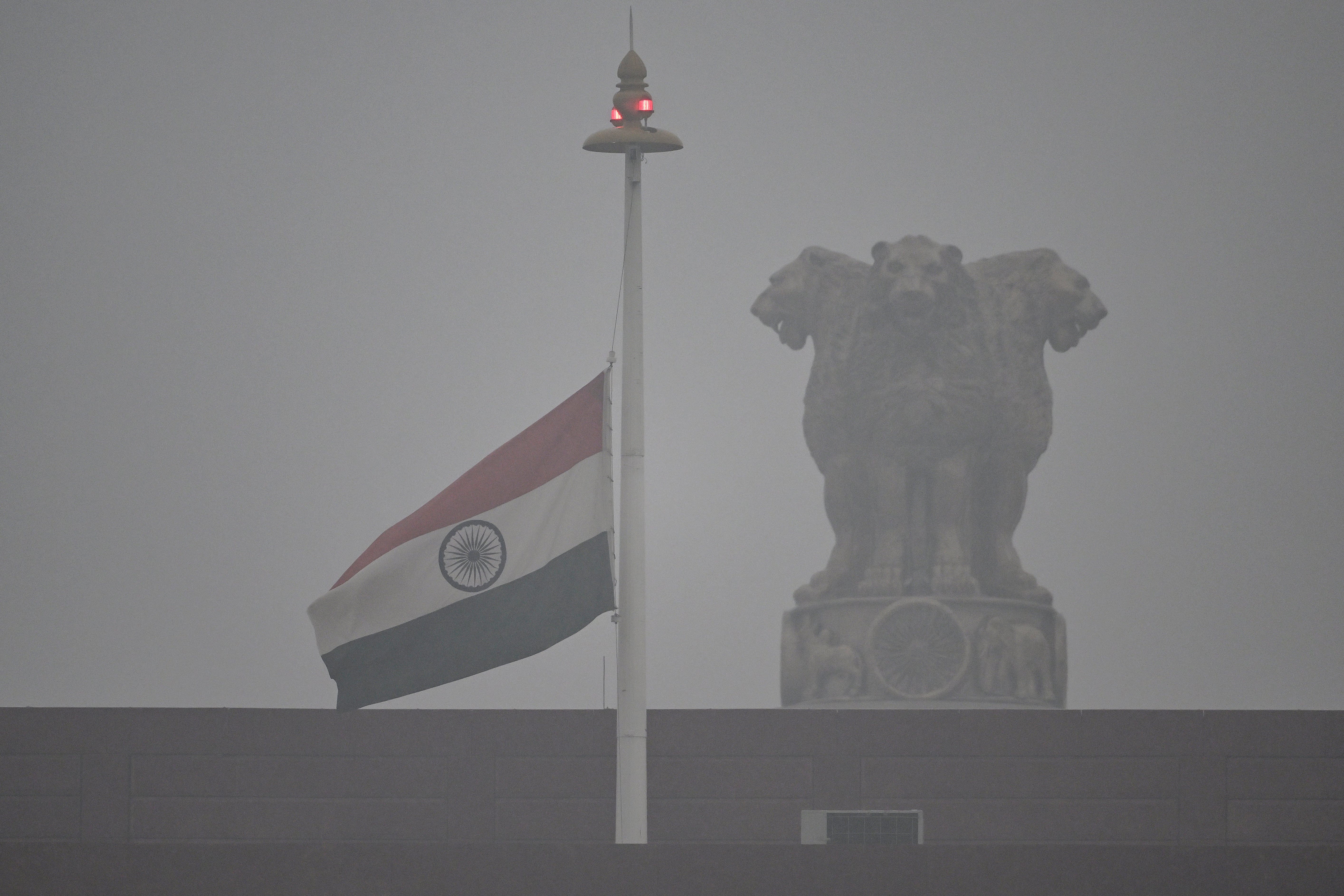 The Indian national flag flies at half-mast over the national parliament