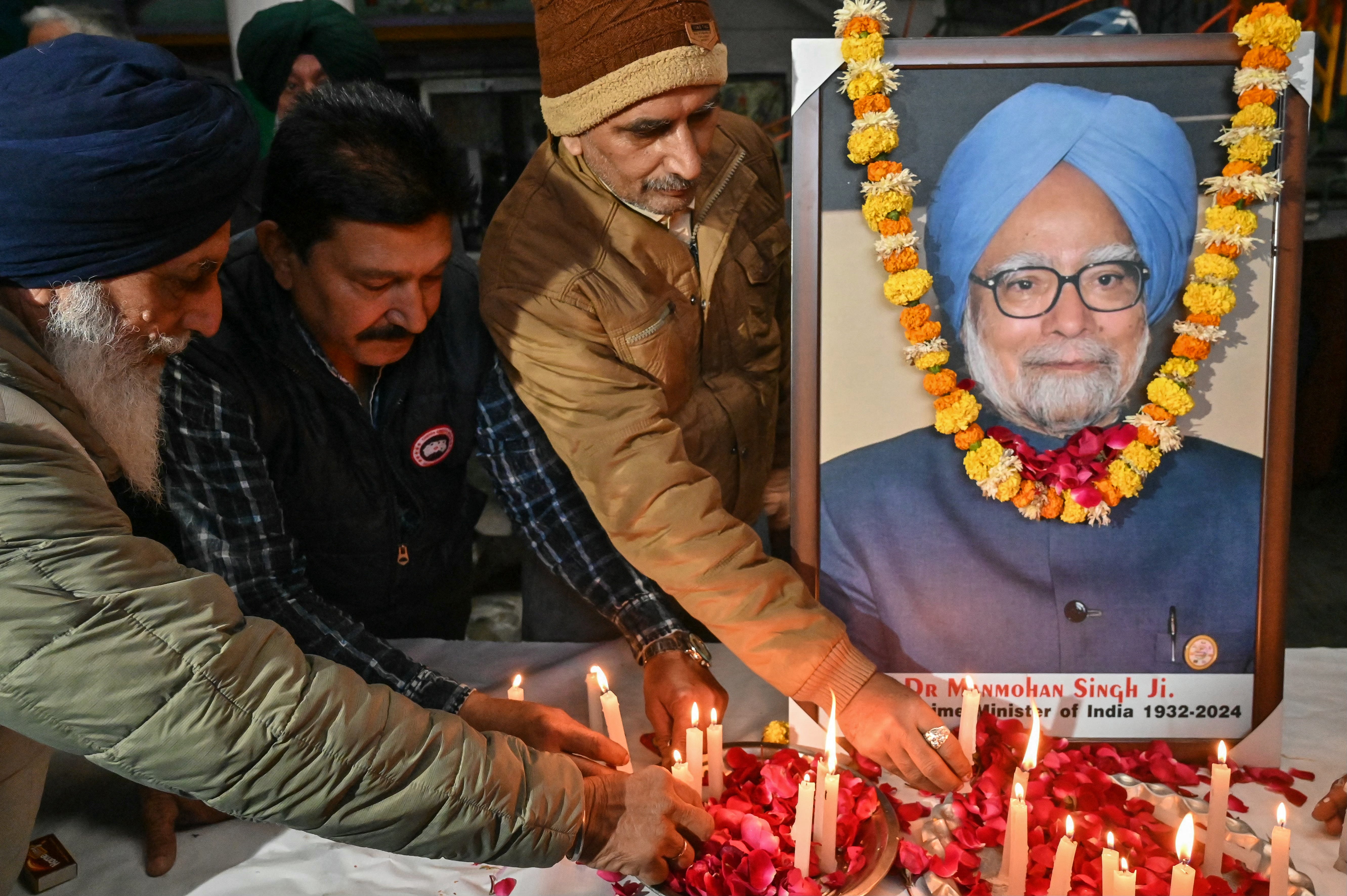 Members of the Congress party light candles in homage to Manmohan Singh