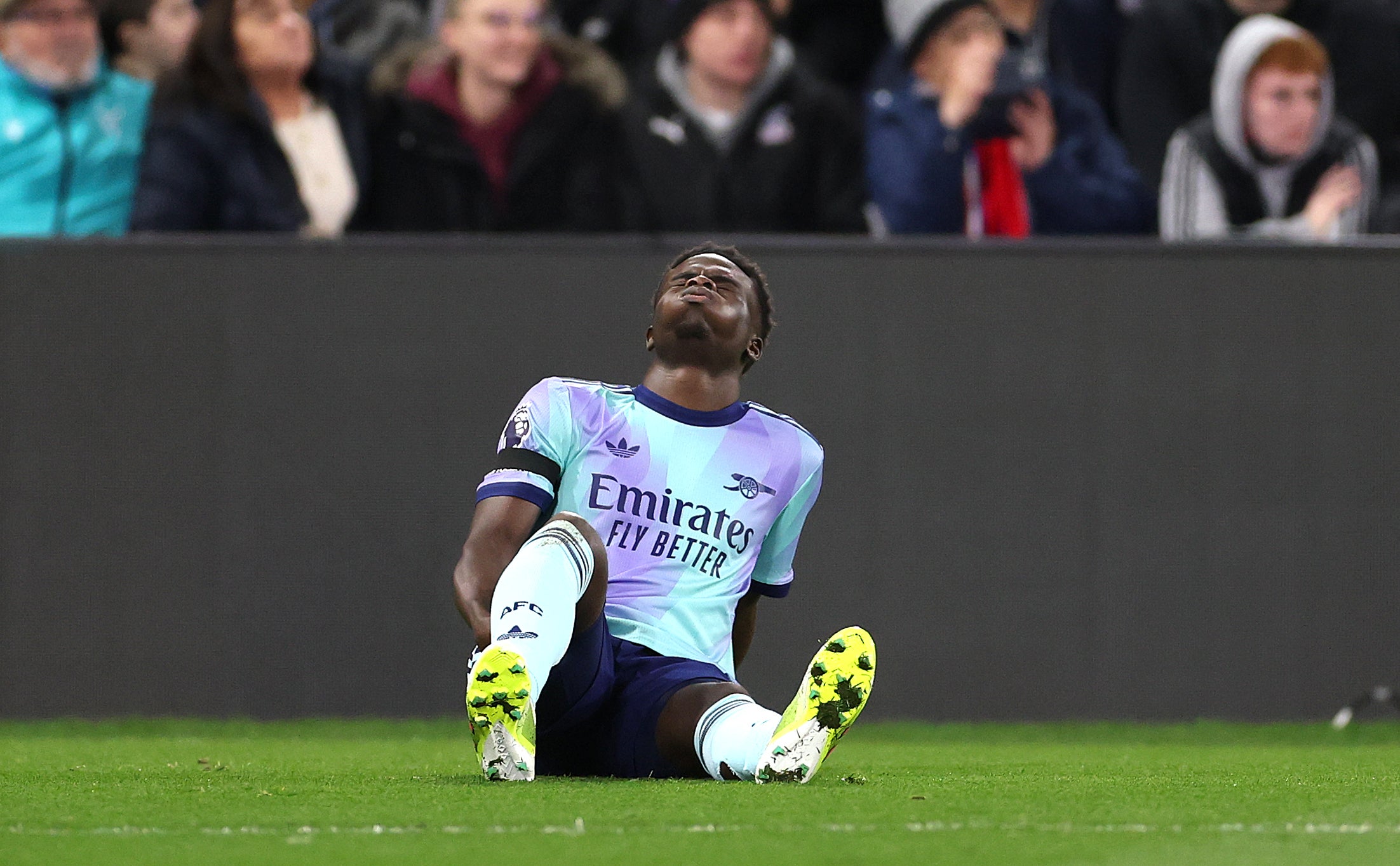 Bukayo Saka holds his hamstring in pain as Selhurst Park