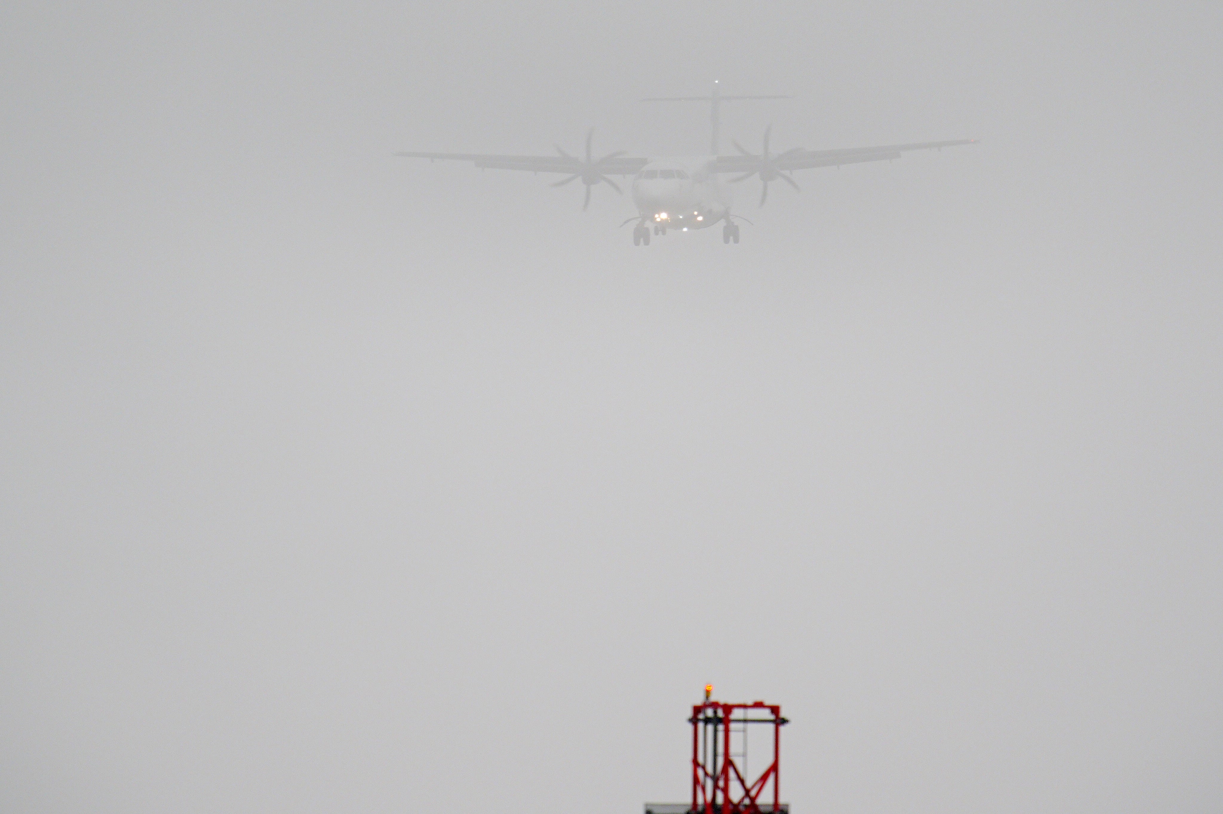 A plane lands in the mist at Cardiff Airport