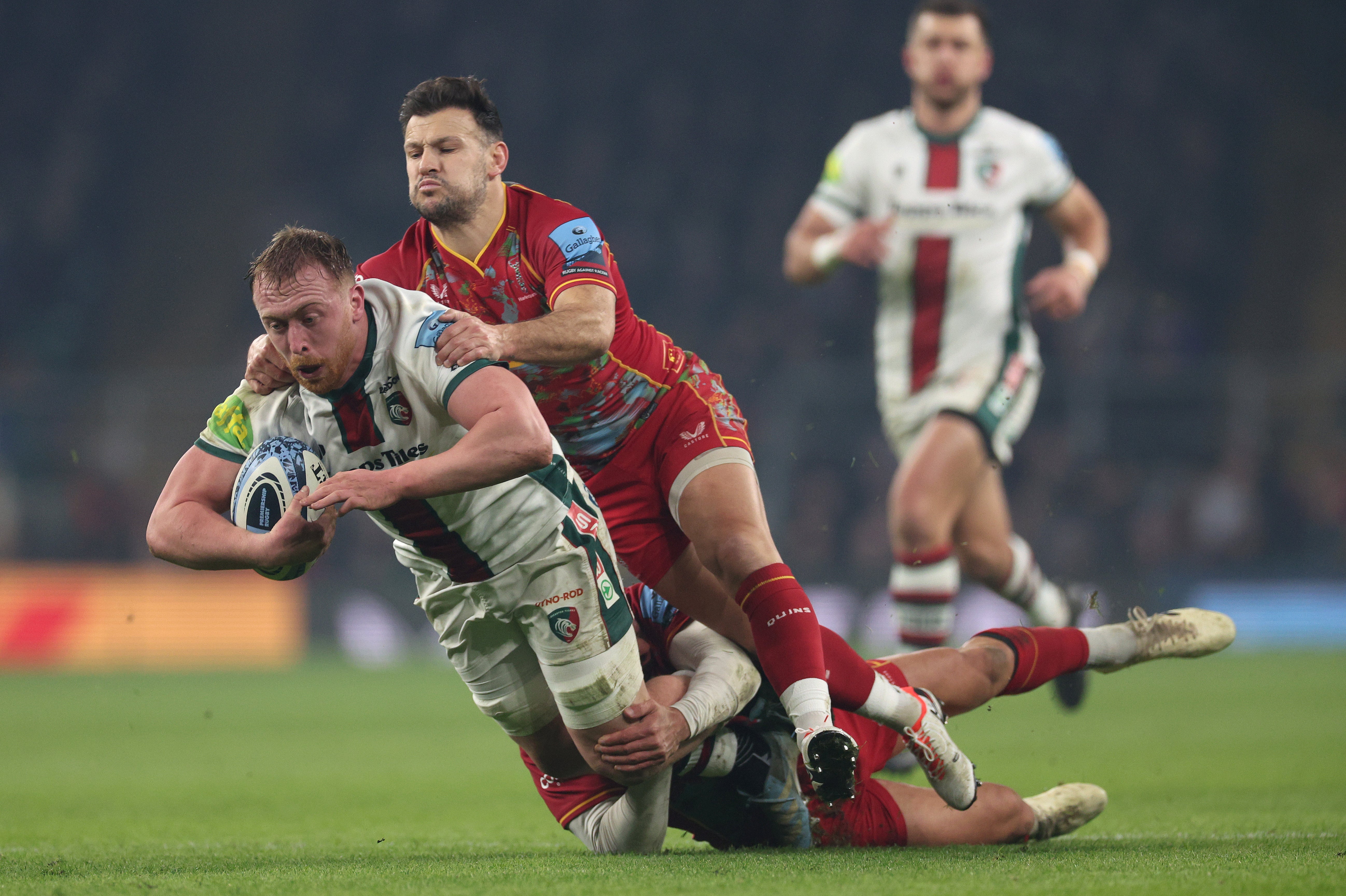 Tommy Reffell of Leicester Tigers is tackled by Danny Care and Nick David