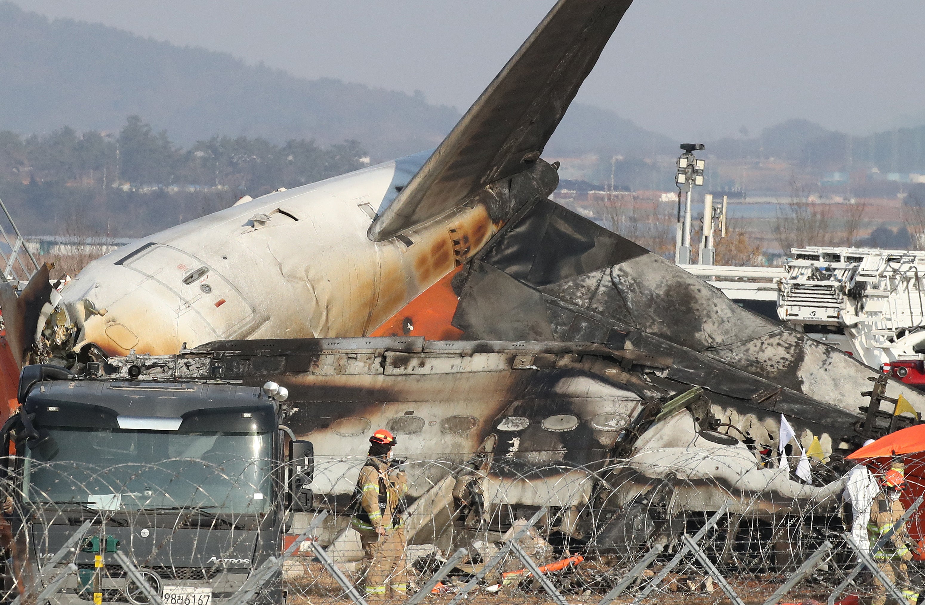 Firefighters and rescue team work at the wreckage of the passenger plane