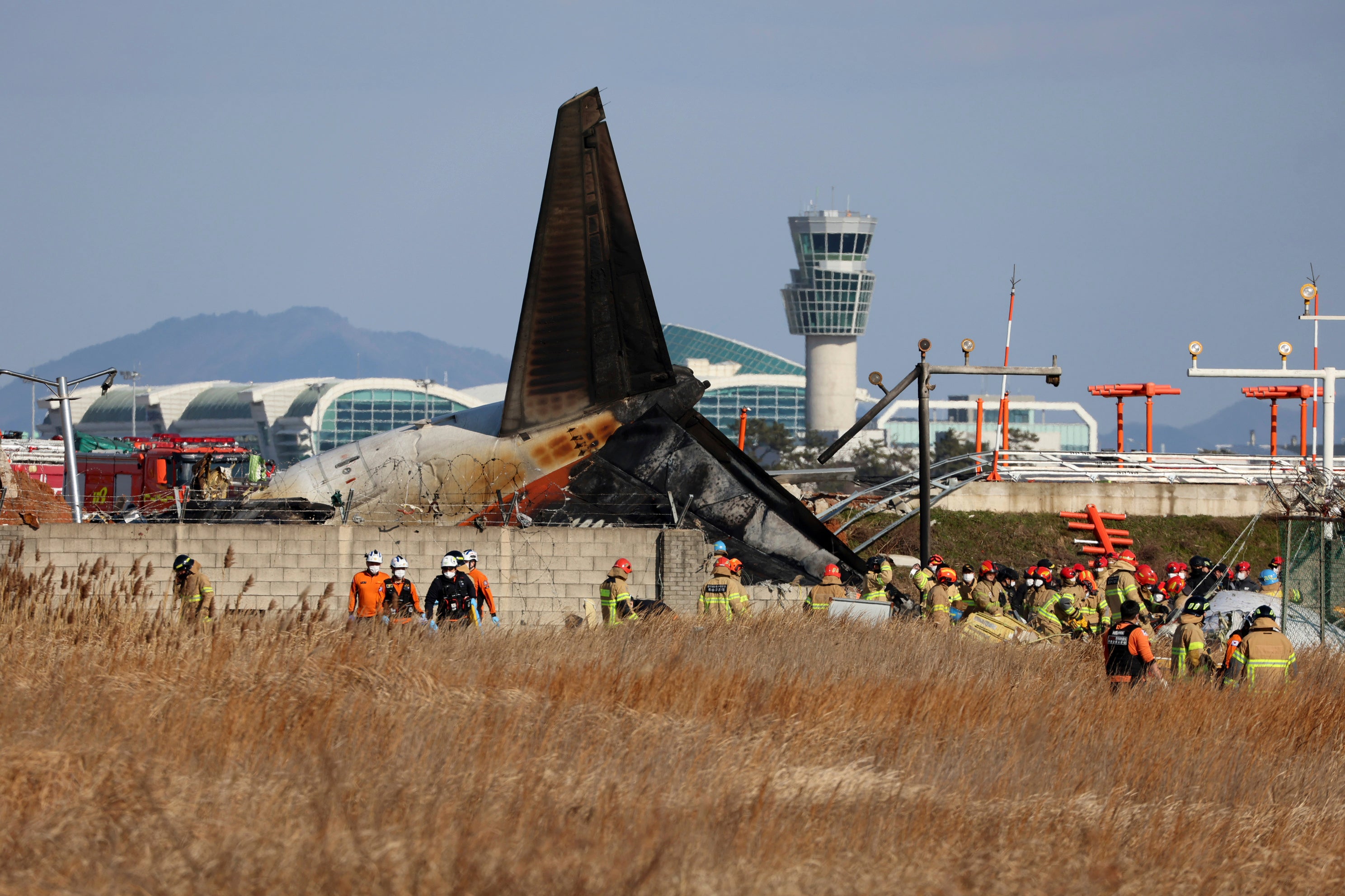 Firefighters and rescue teams work at the wreckage of the passenger plane at Muan international airport