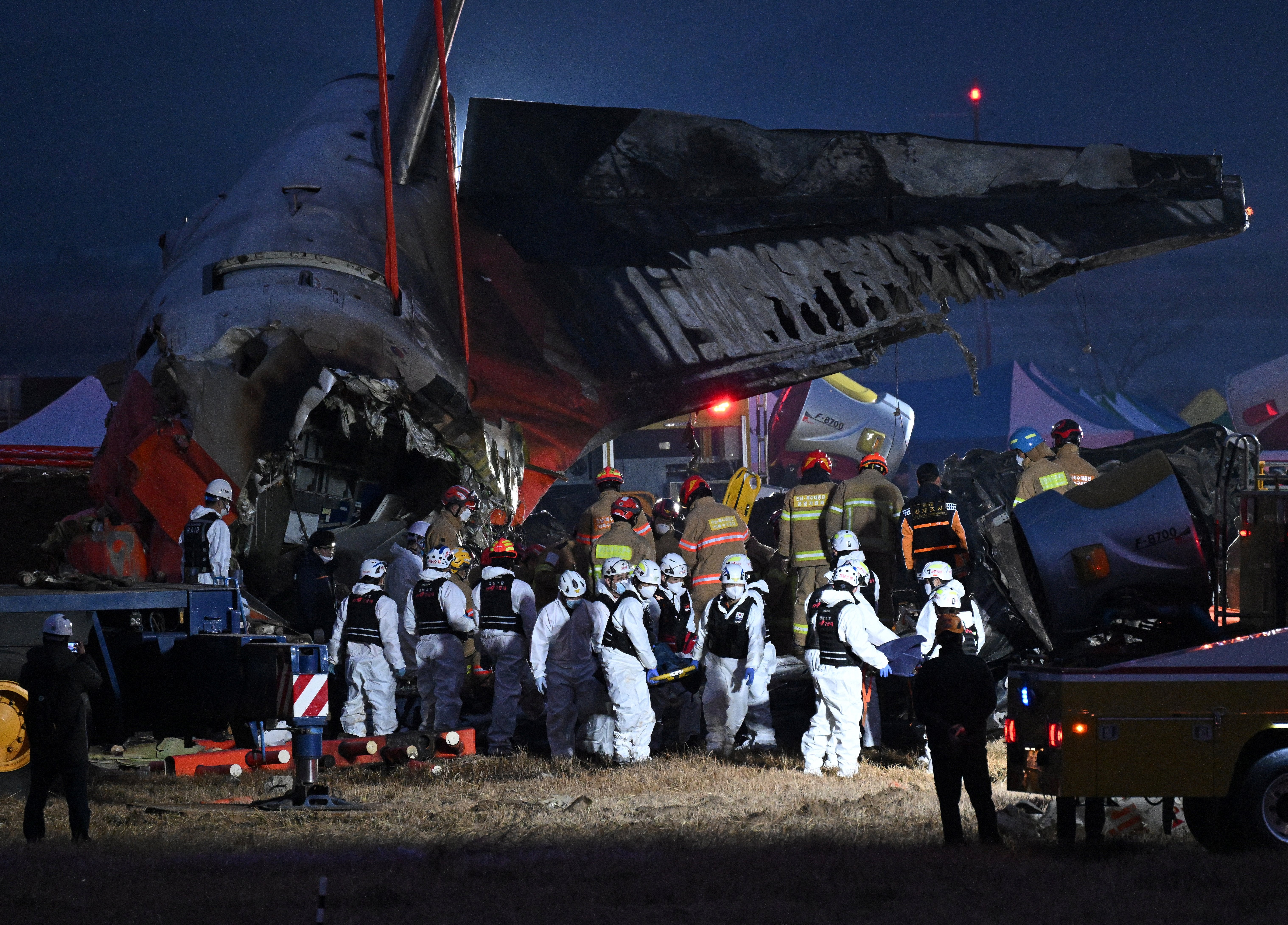 Firefighters carry the body of a victim away from the plane wreckage