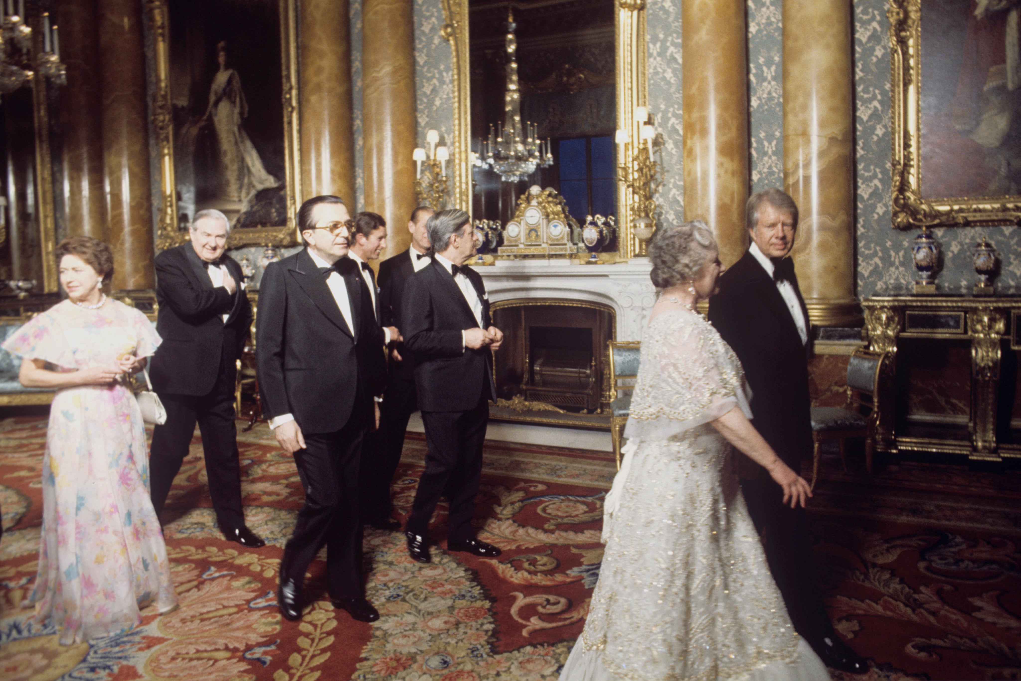 The Queen Mother walks with President Jimmy Carter in the Blue Drawing Room at Buckingham Palace (Archive/PA)