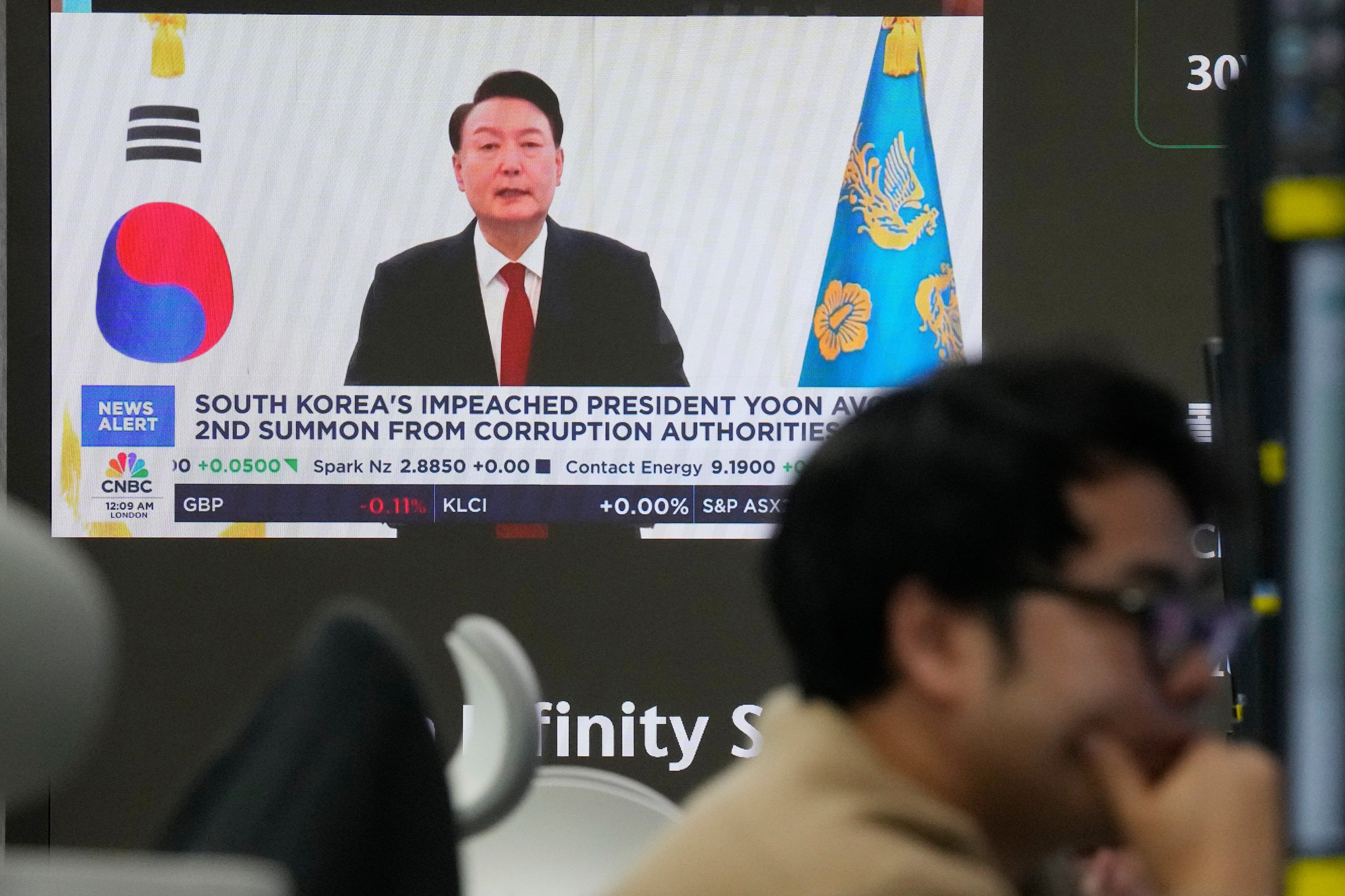 A TV screen shows a file image of South Korean president Yoon Suk Yeol being broadcast at the KEB Hana Bank headquarters in Seoul on 26 December 2024