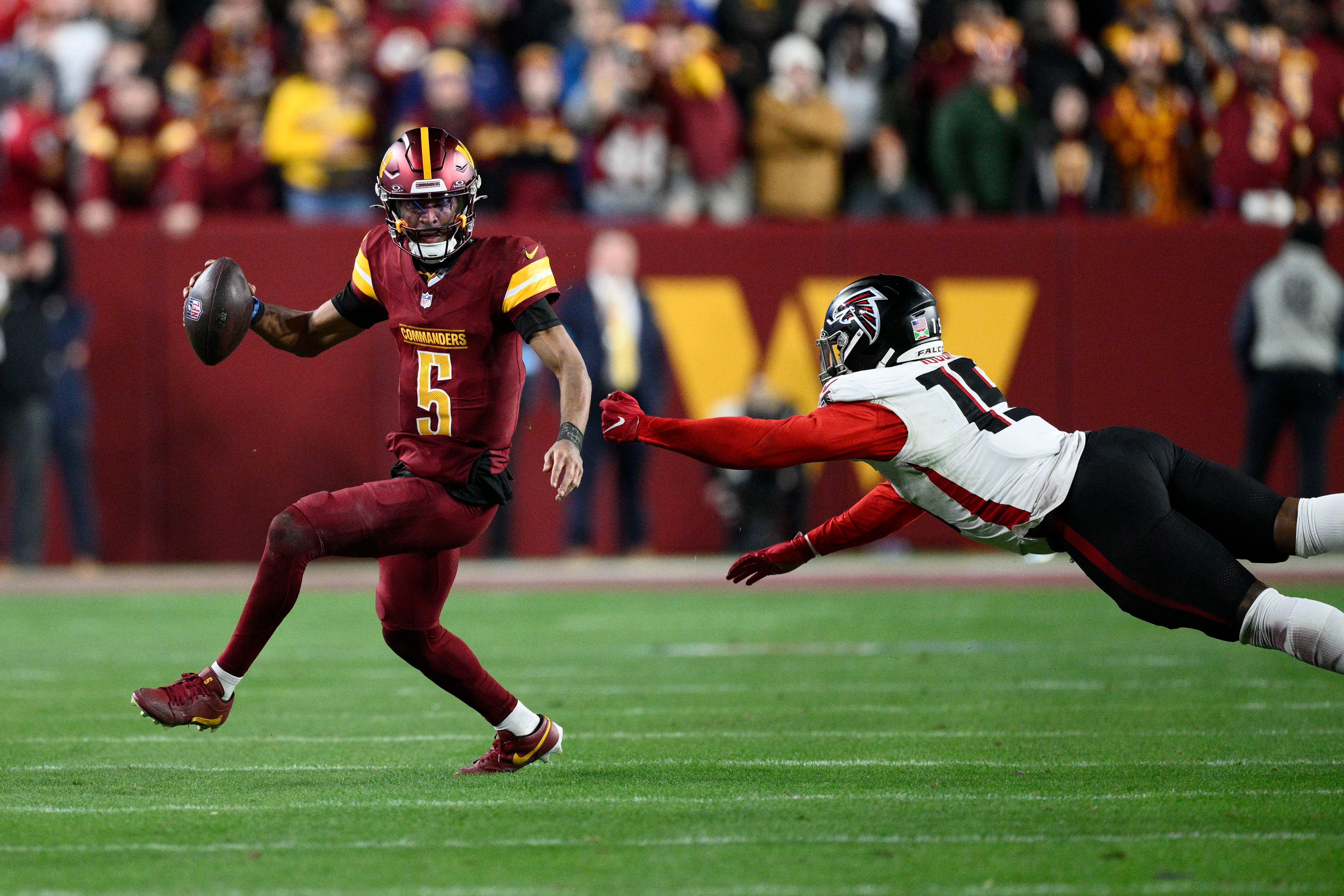 Washington Commanders quarterback Jayden Daniels scrambles away from Atlanta Falcons offensive tackle Brandon Parker (Nick Wass/AP)